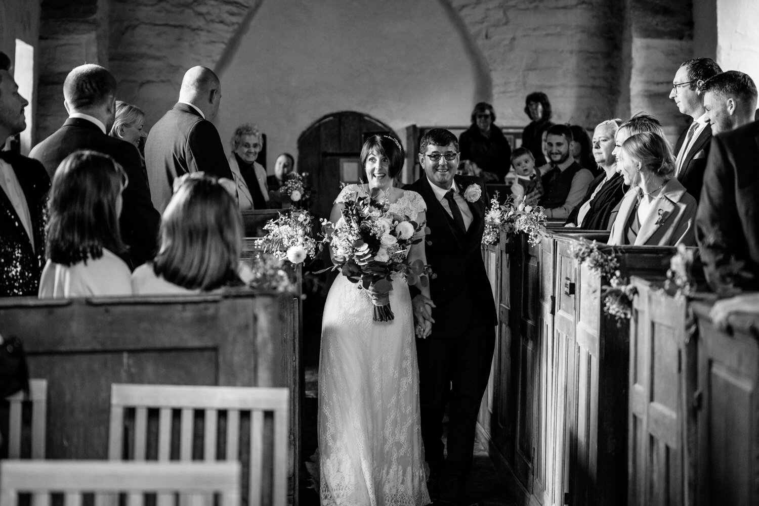 Bride and father walking down aisle during Powys wedding