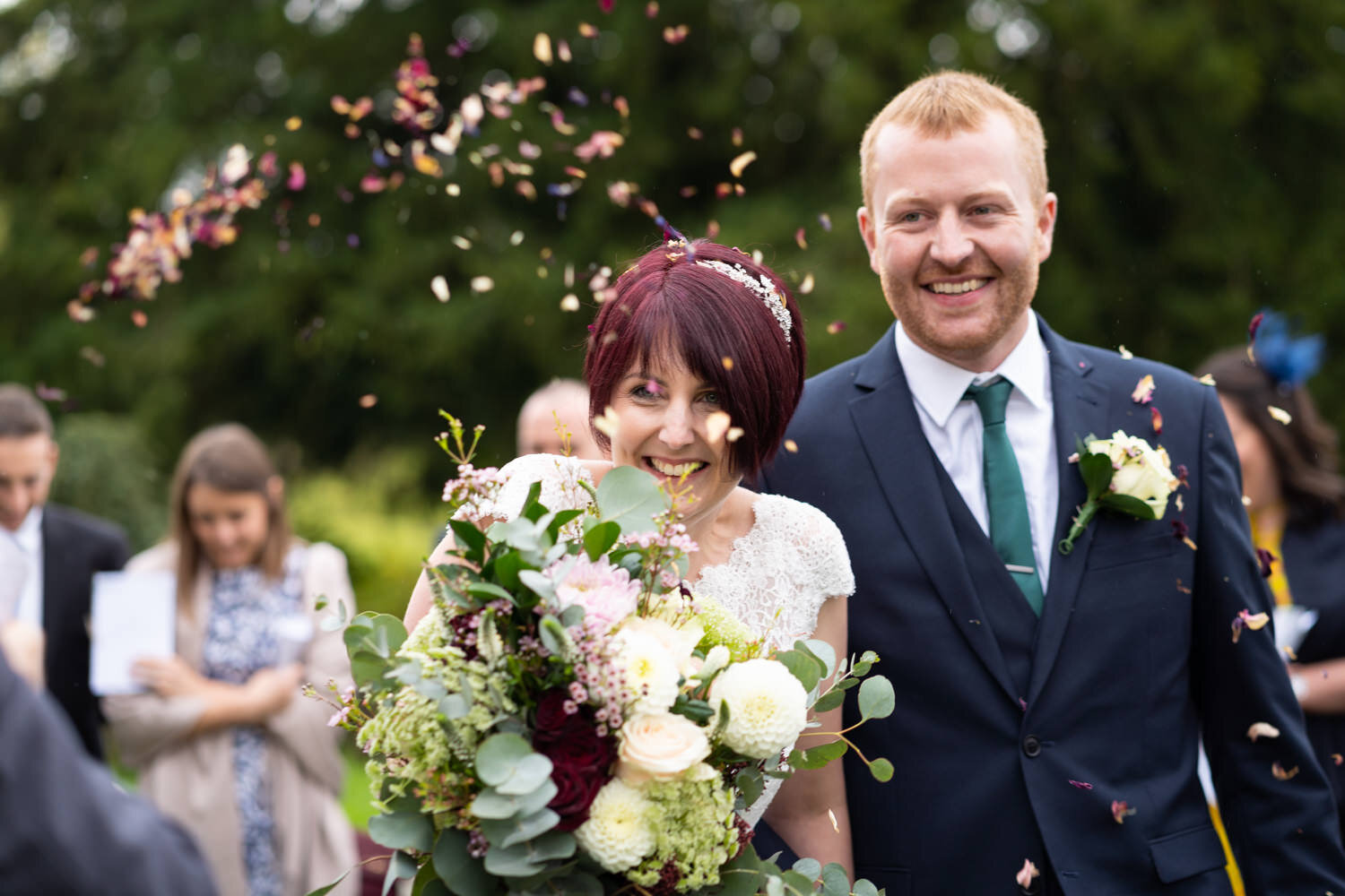 Laughter from bride and groom during confetti