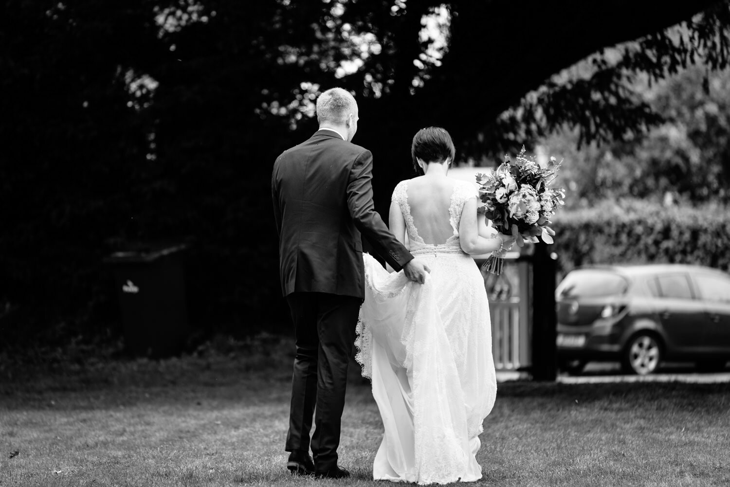 Groom holding brides dress up