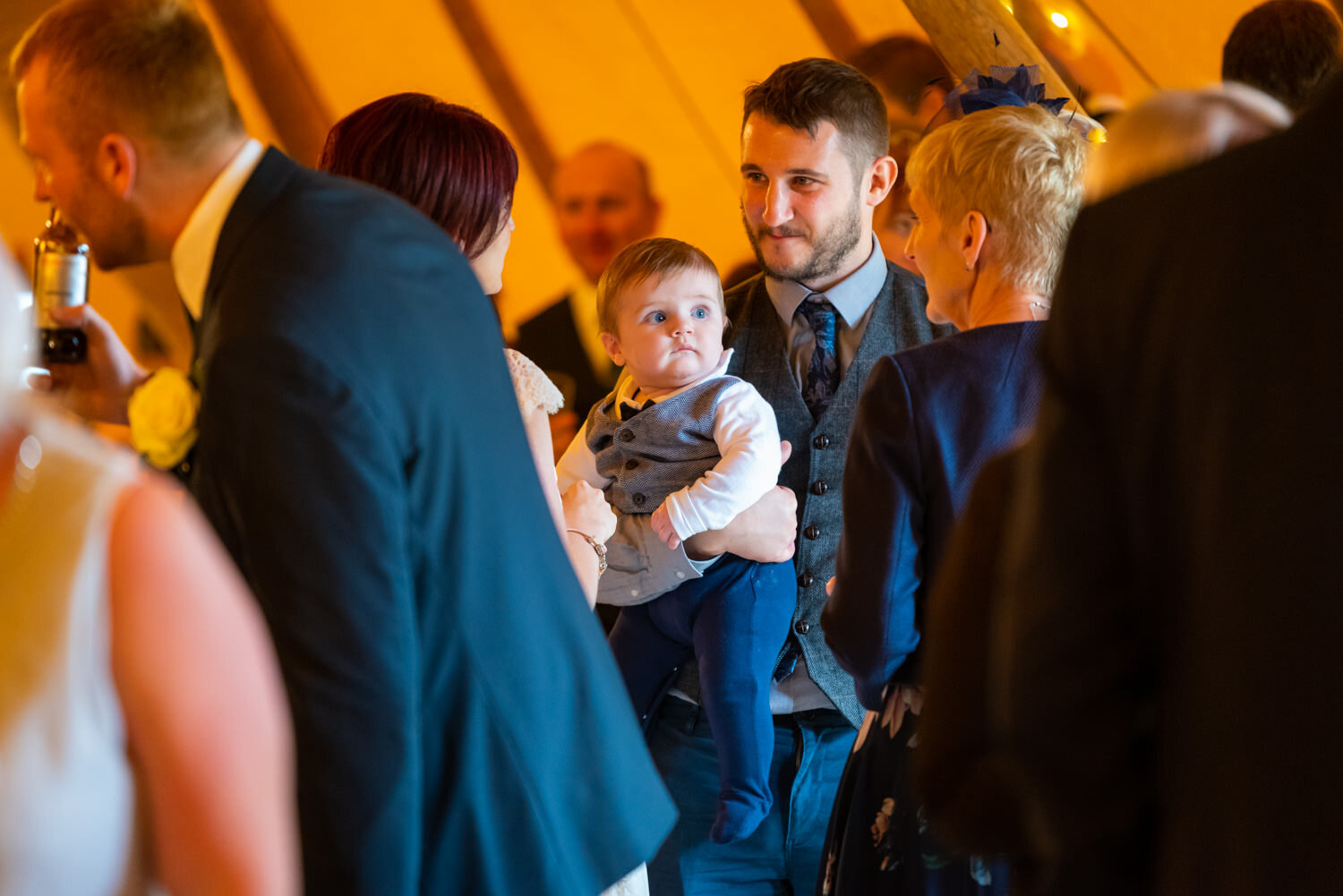Baby looking at wedding guest with funny face