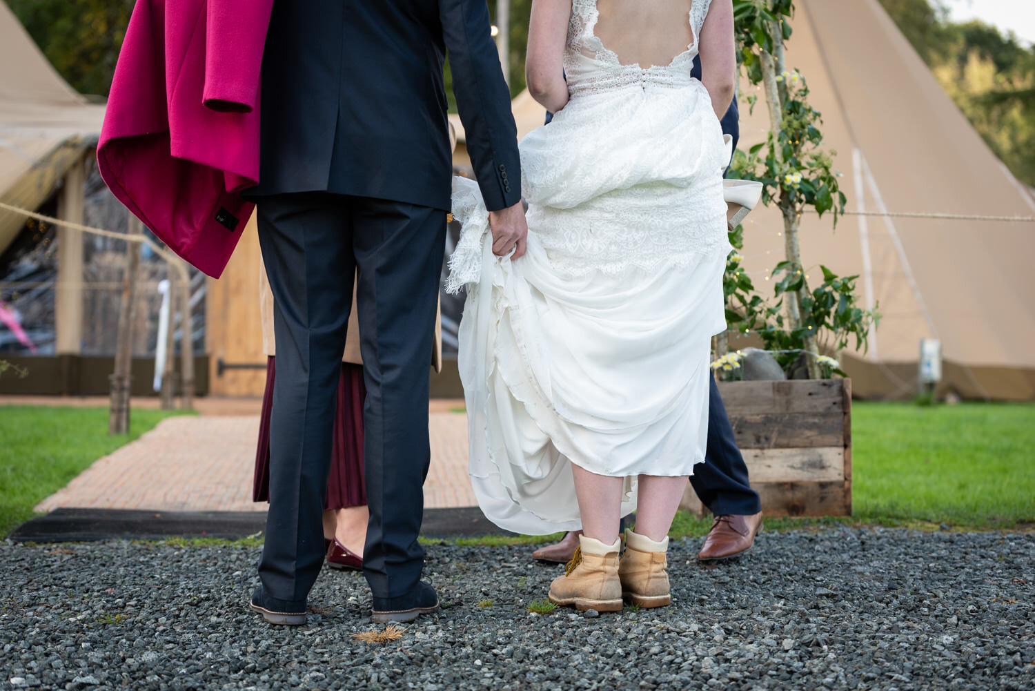 Bride wearing boots and groom holding her dress up