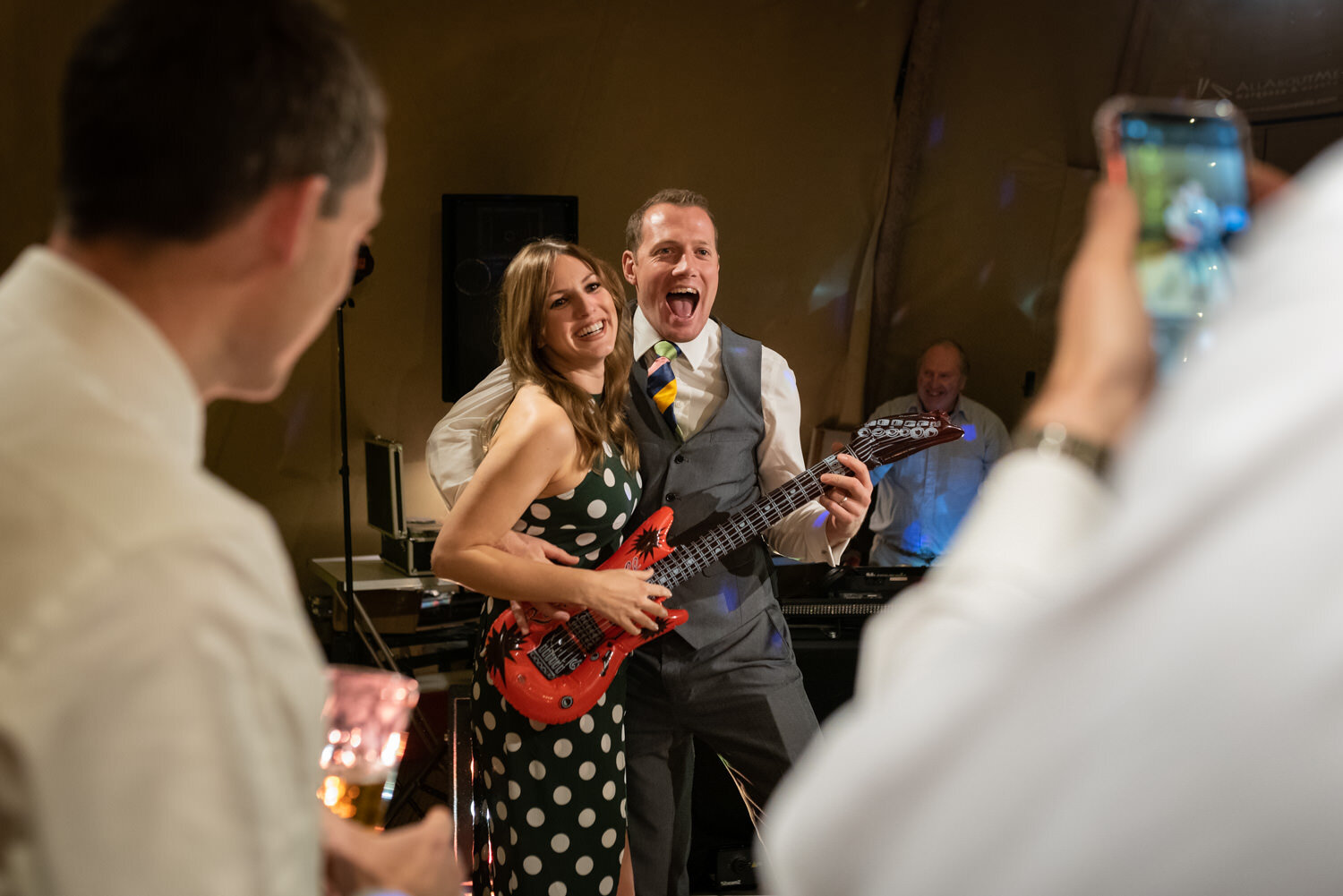 Wedding guests during party with blow up guitar 