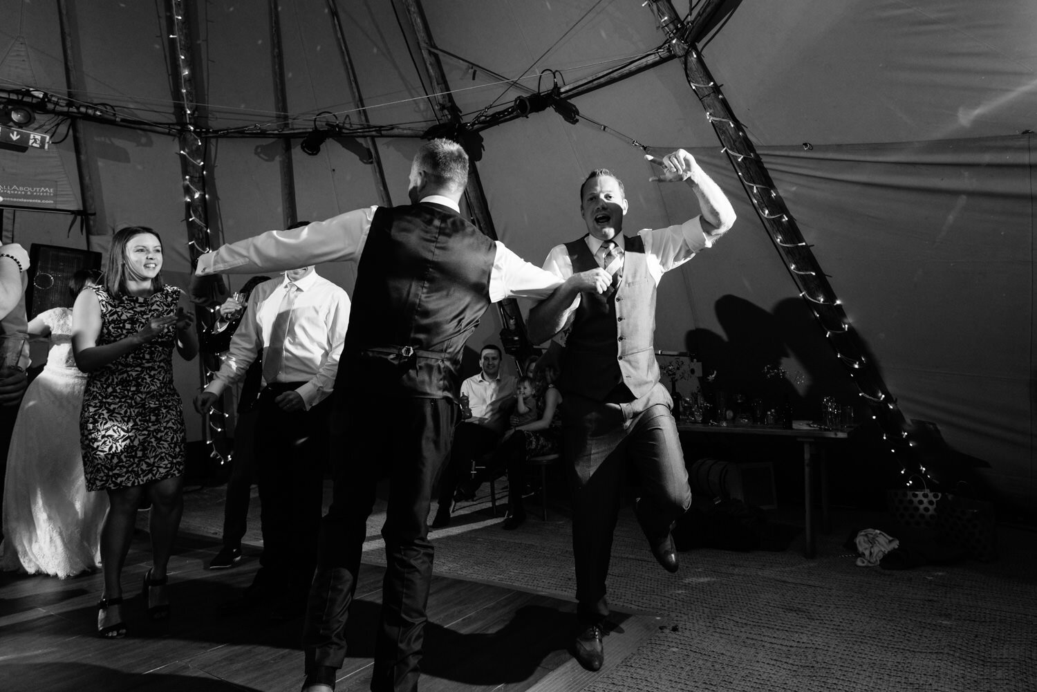 Groom and friend dancing arm in arm