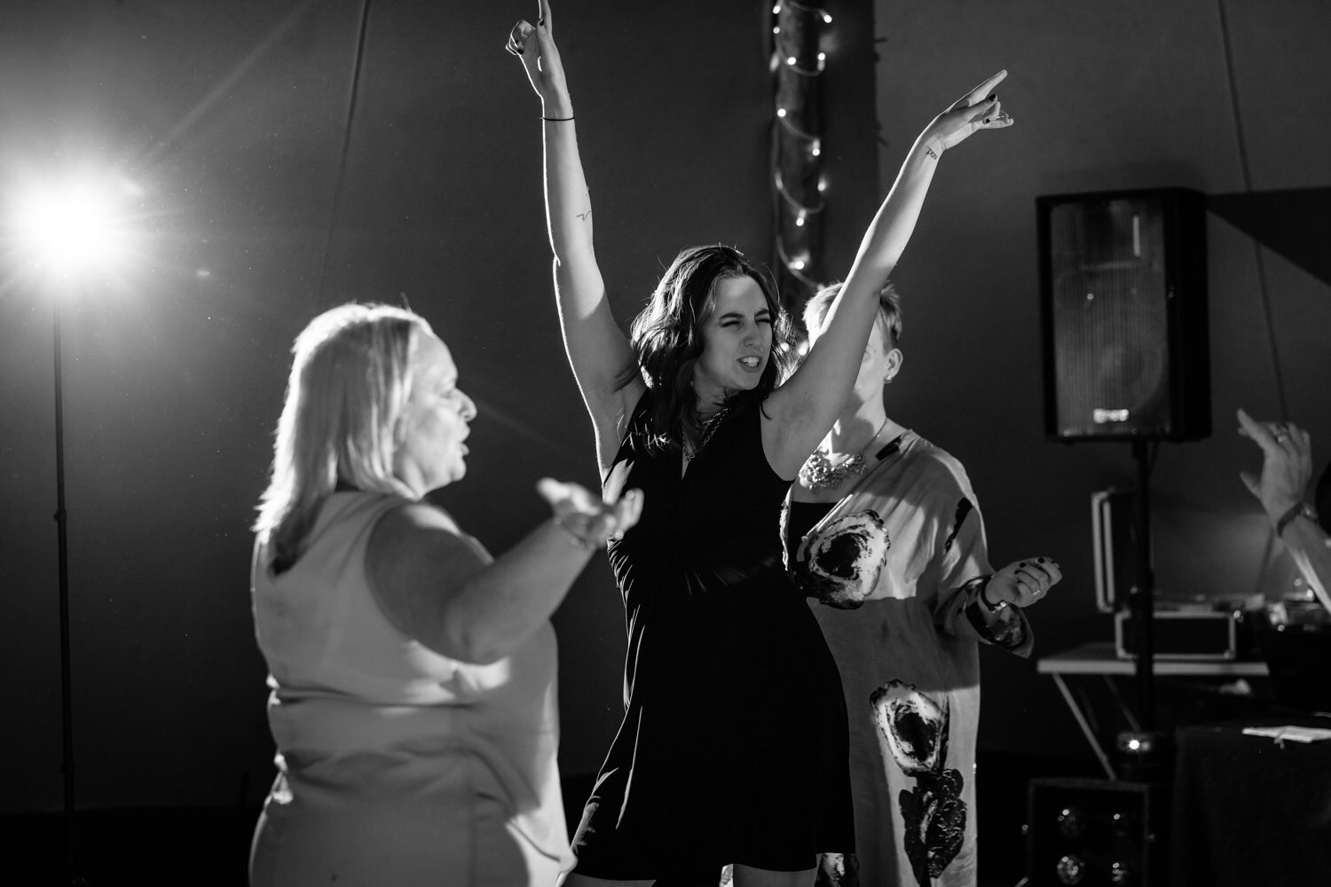 Guest dancing with arms in the air at wedding party