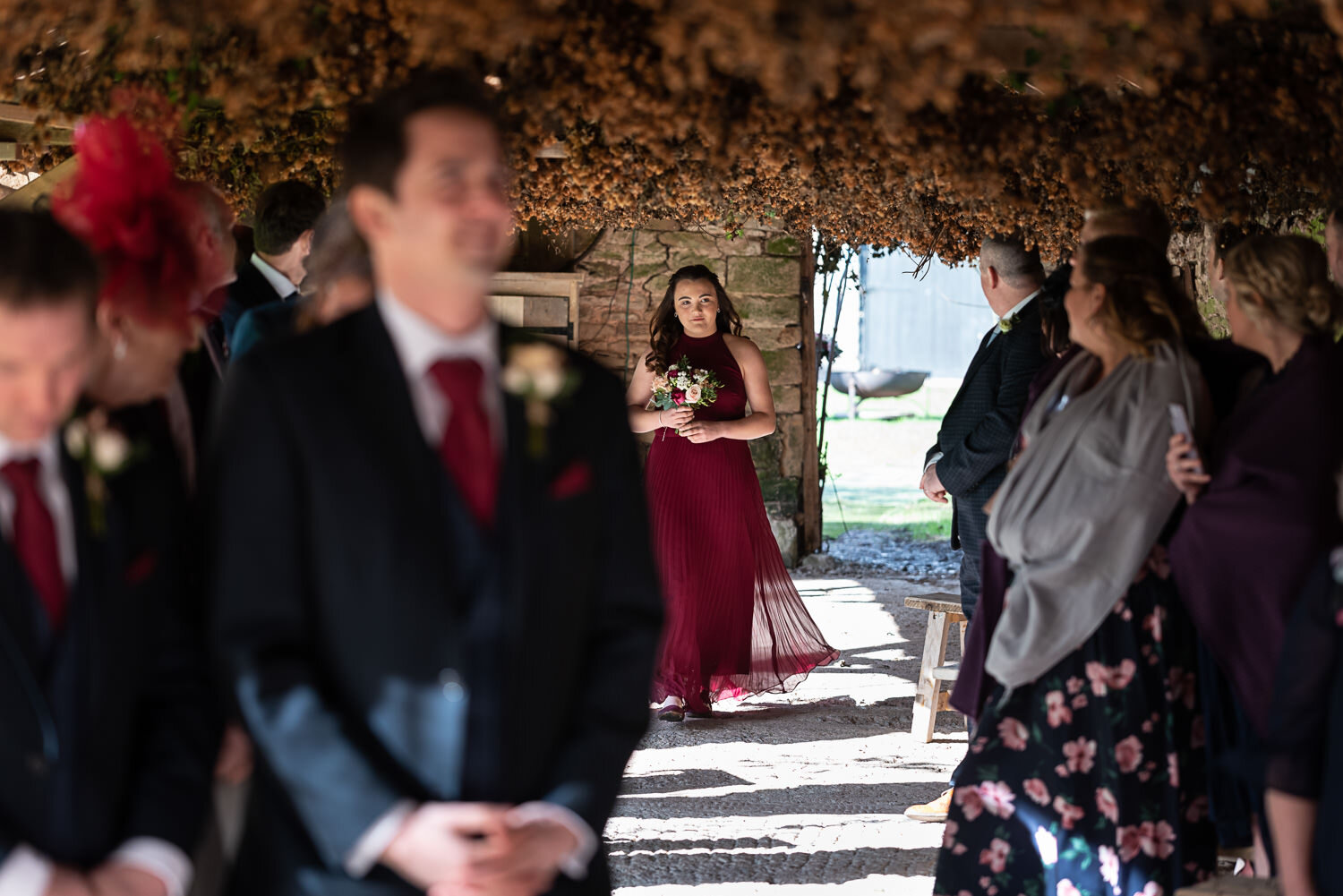 Bridesmaid walking down aisle at Lyde Court