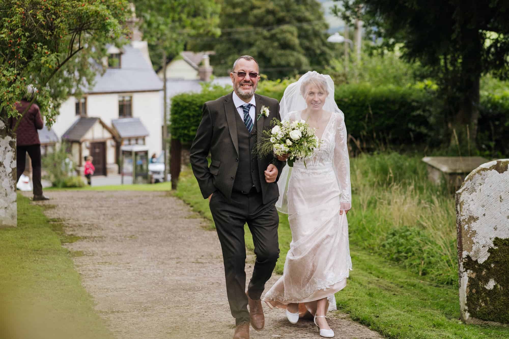 Bride and dad walking up to church