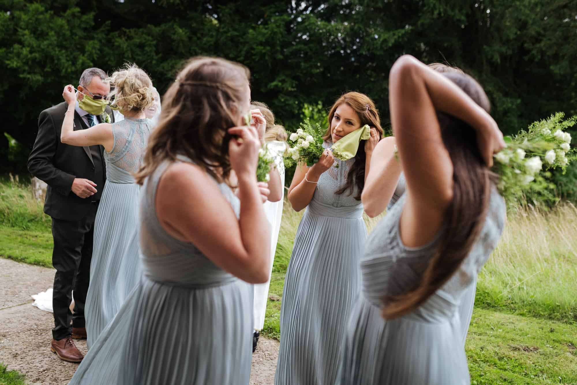 Bridal party putting face masks on at covid wedding