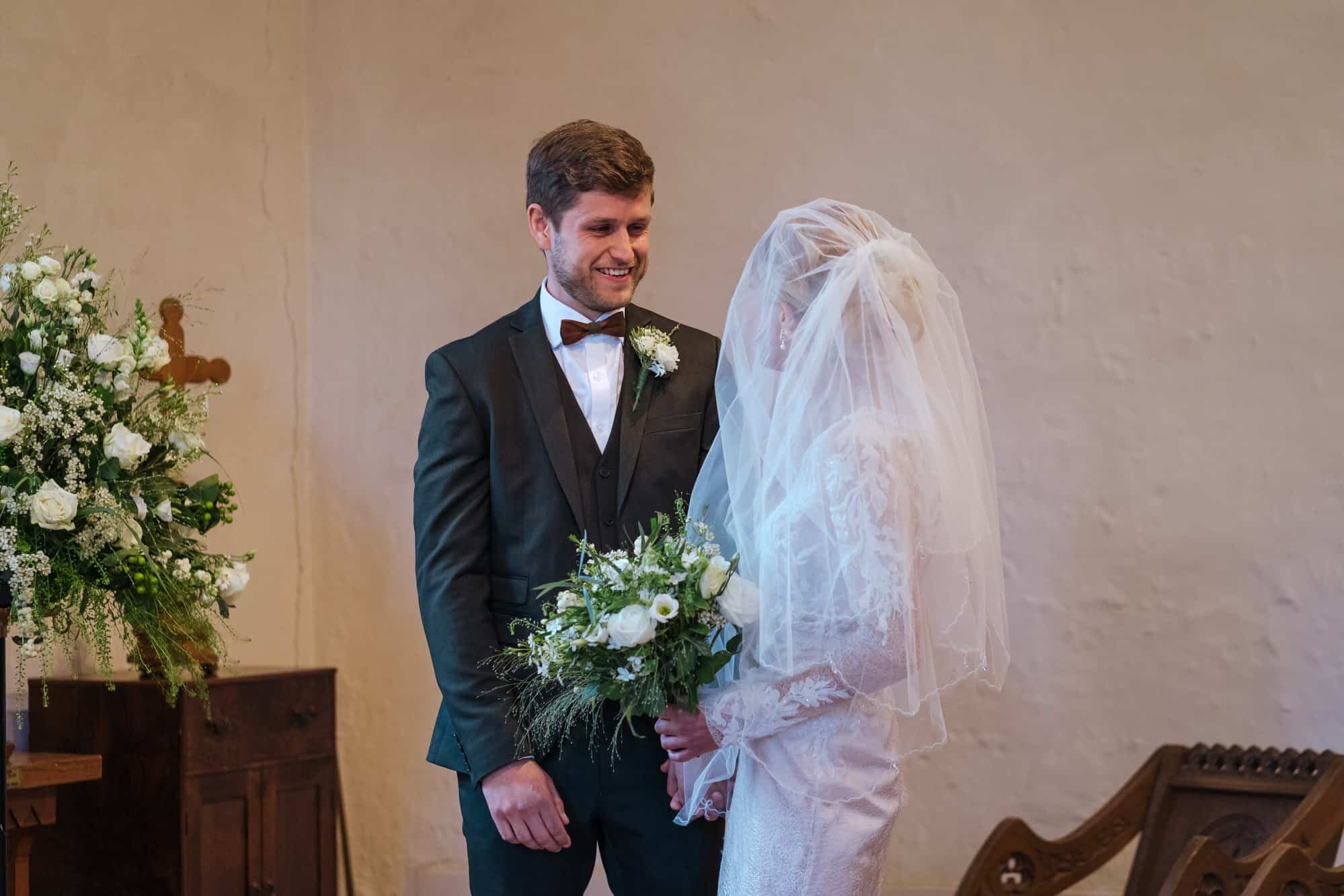 Groom smiling at bride in church