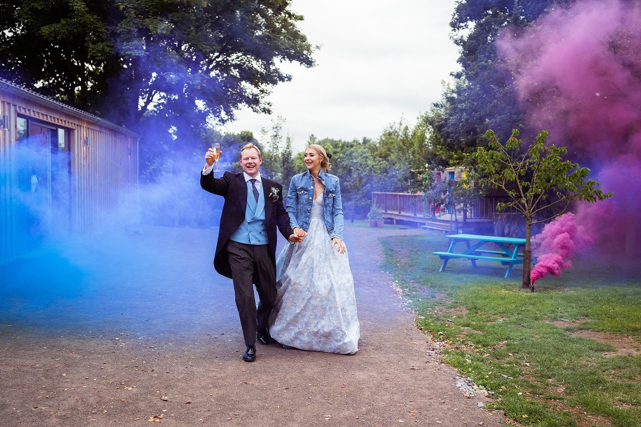 Bride and groom walking through smoke bombs