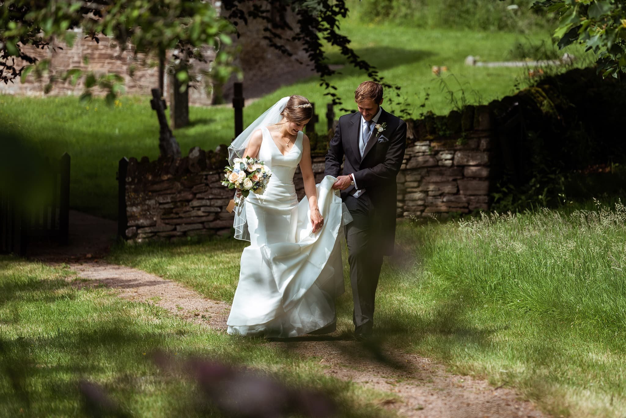 bride and groom walking from church at Dewsall Court