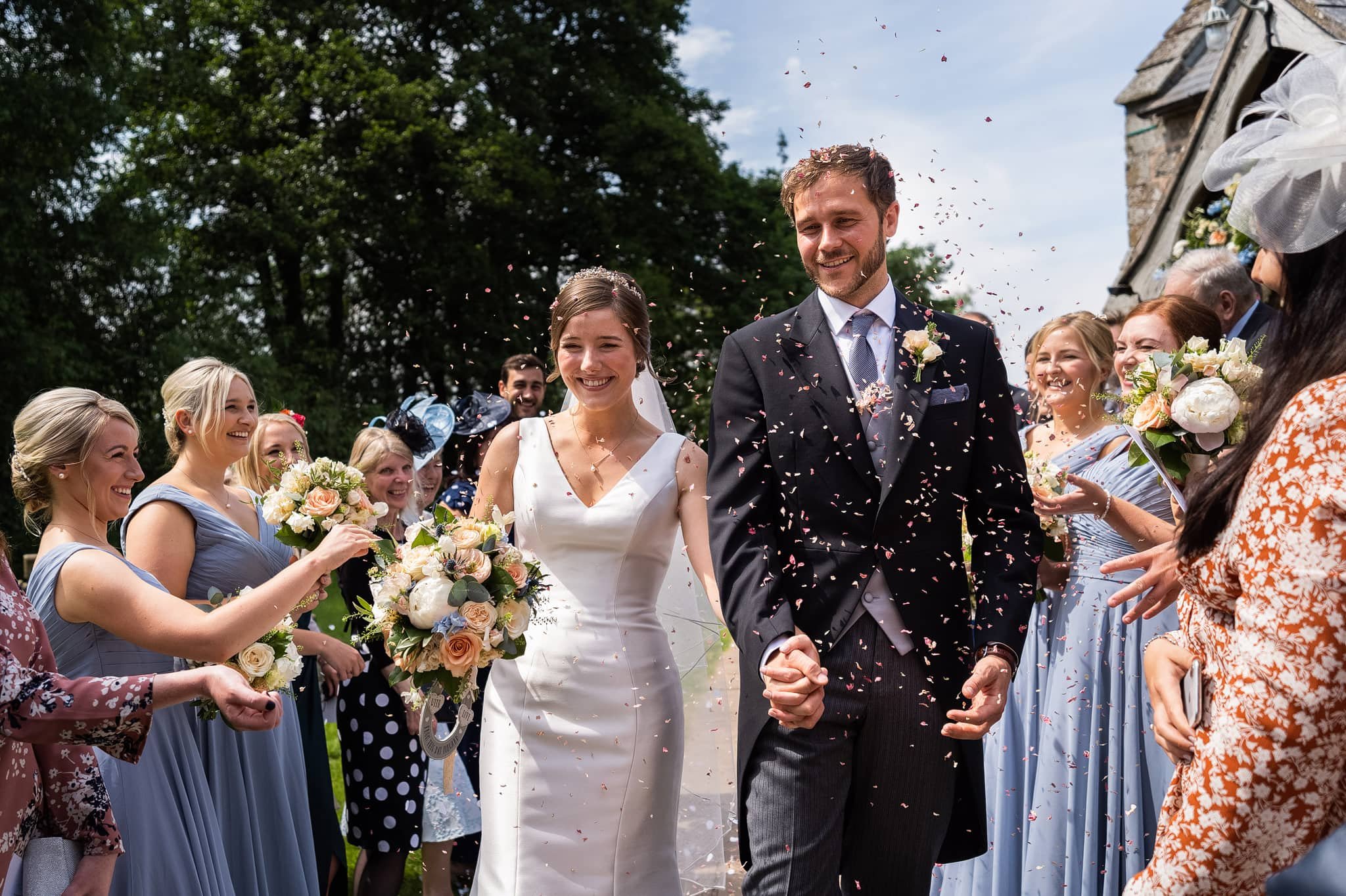 bride and groom walking through confetti 