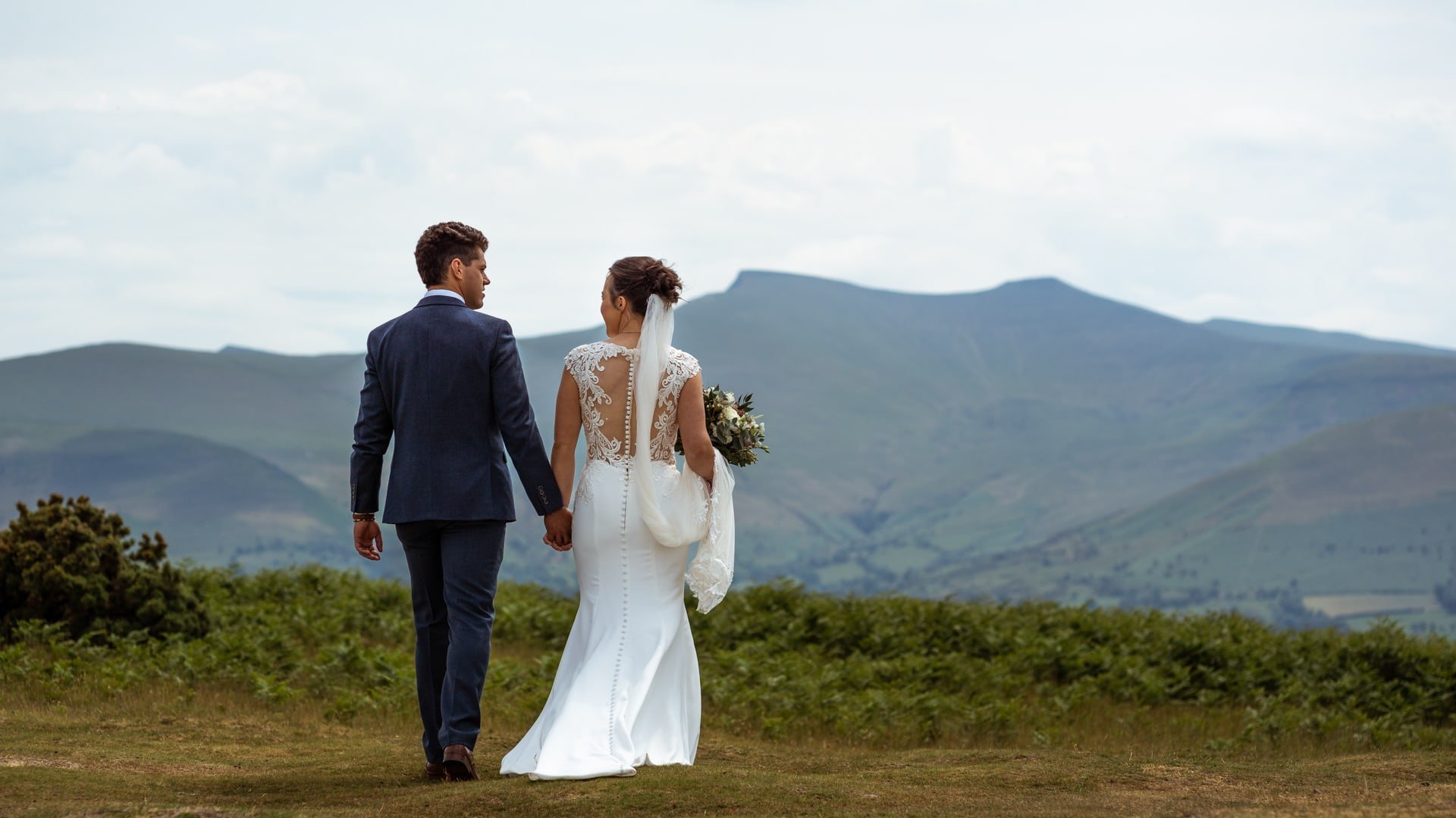 Bride &amp; groom walking towards Brecon Beacons