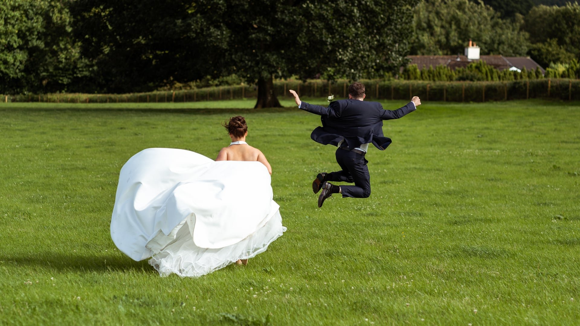 Bride &amp; groom running and jumping in the air