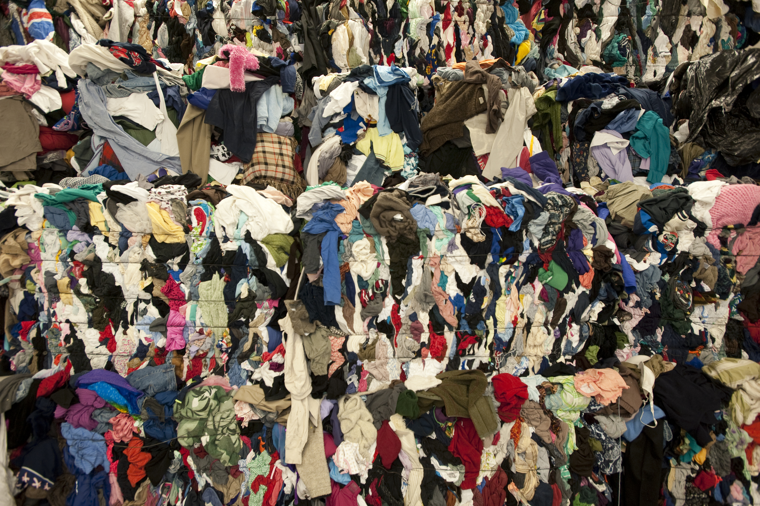 Bundles of clothing waste await recycling. Many discarded clothes end up outside the recycling system, clogging the world's landfills with an estimated 70 lbs per capita of garment waste in the US alone (photo: GreenGlamour )