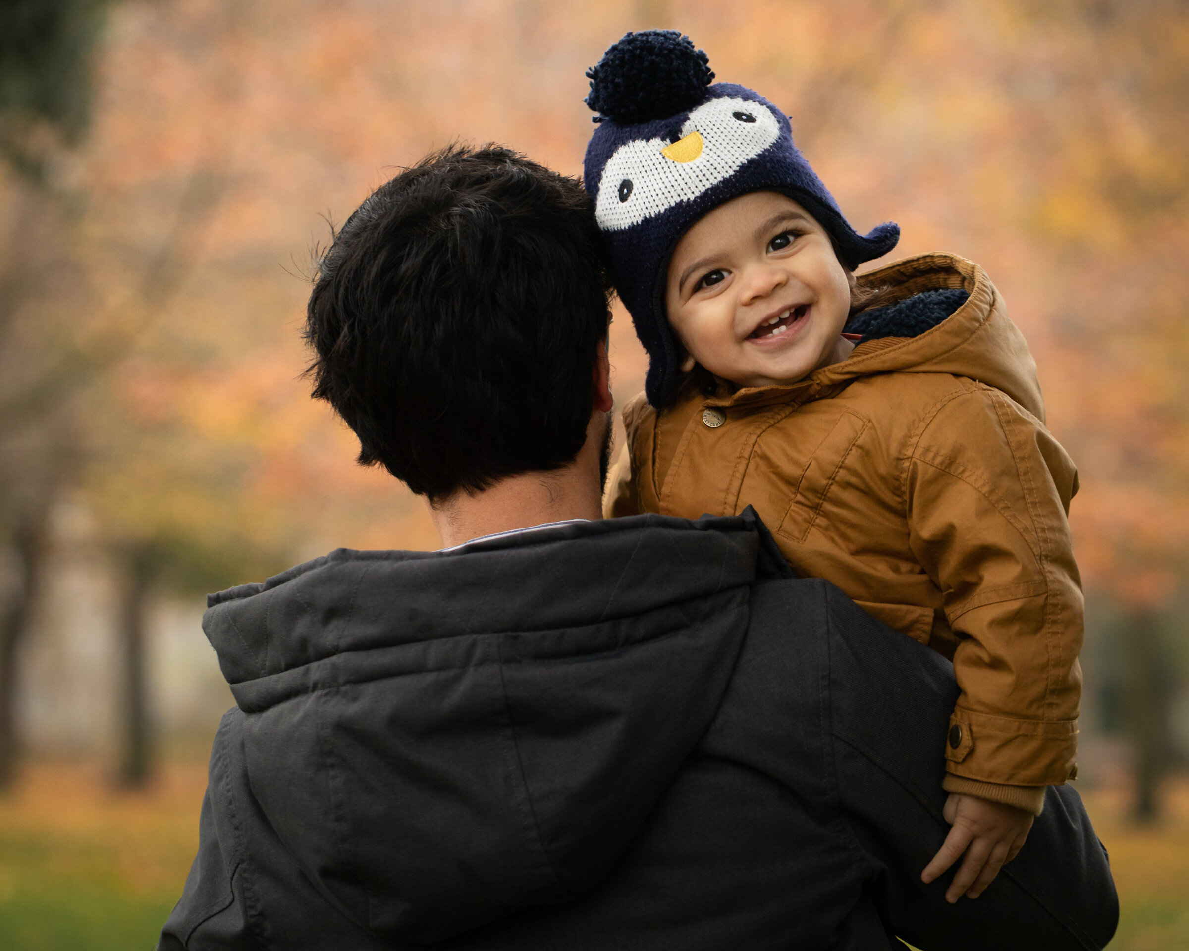 boy and father autumn leaves in background