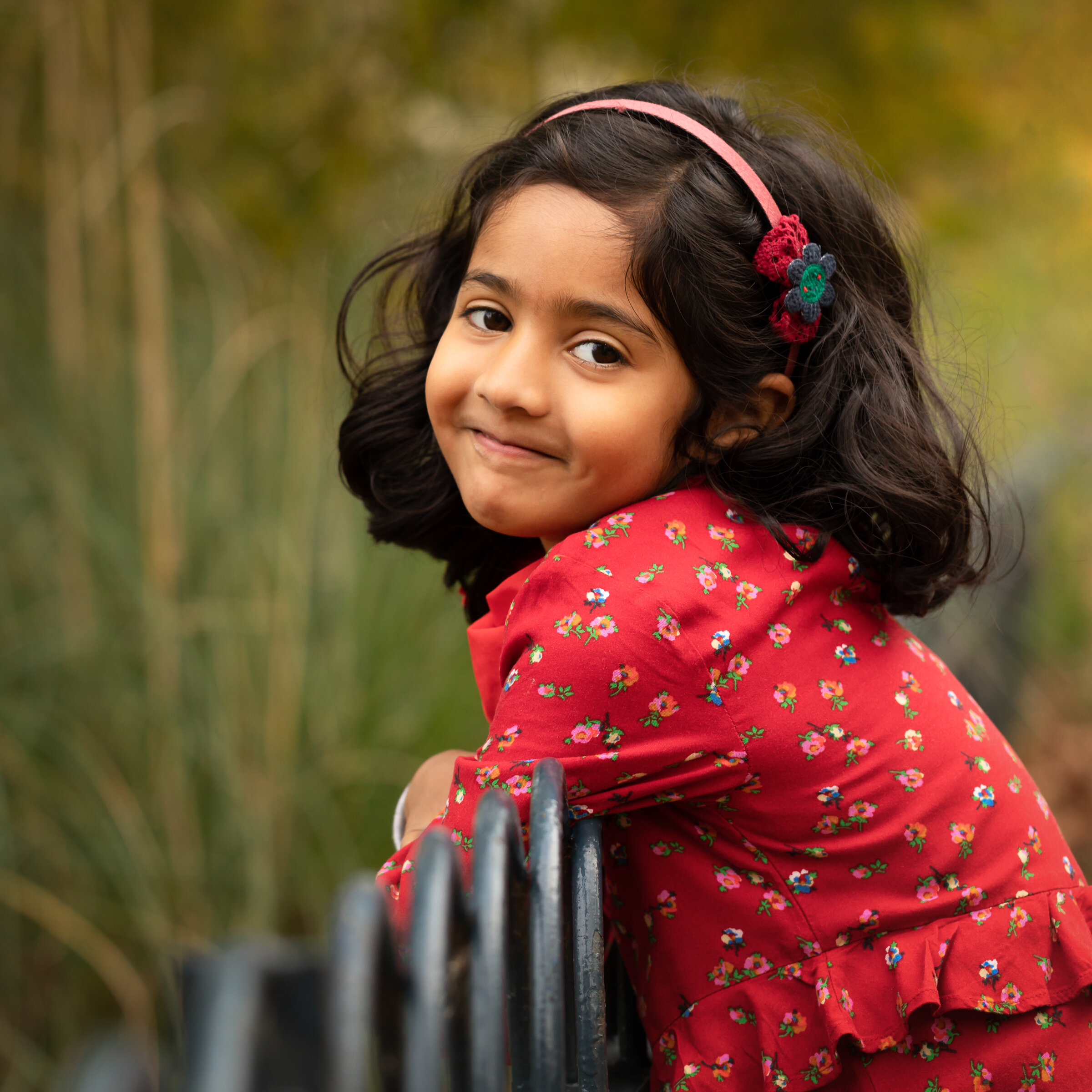 smiling girl leaning on fence