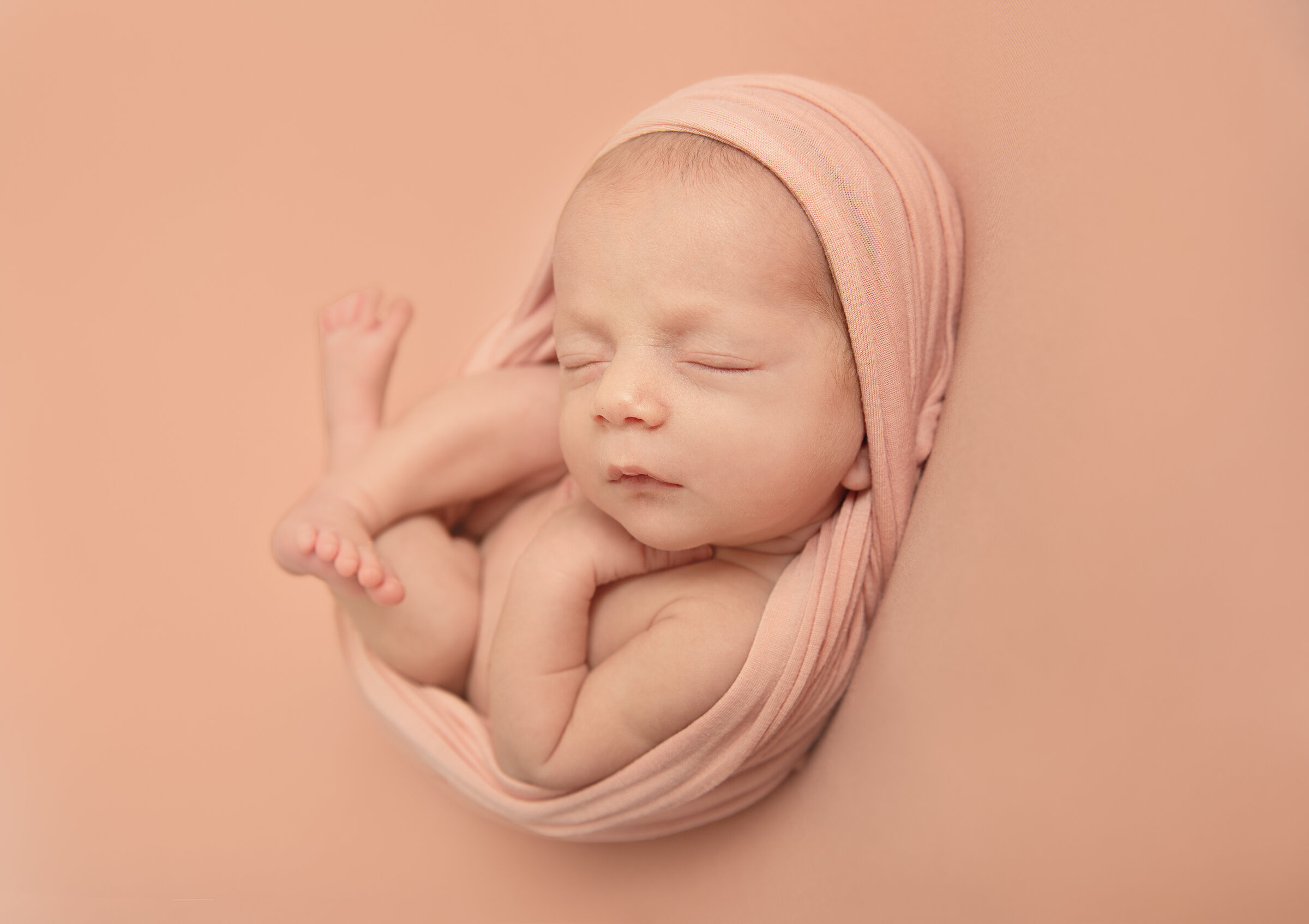 newborn-baby-wrapped-on-back-shot-from-side