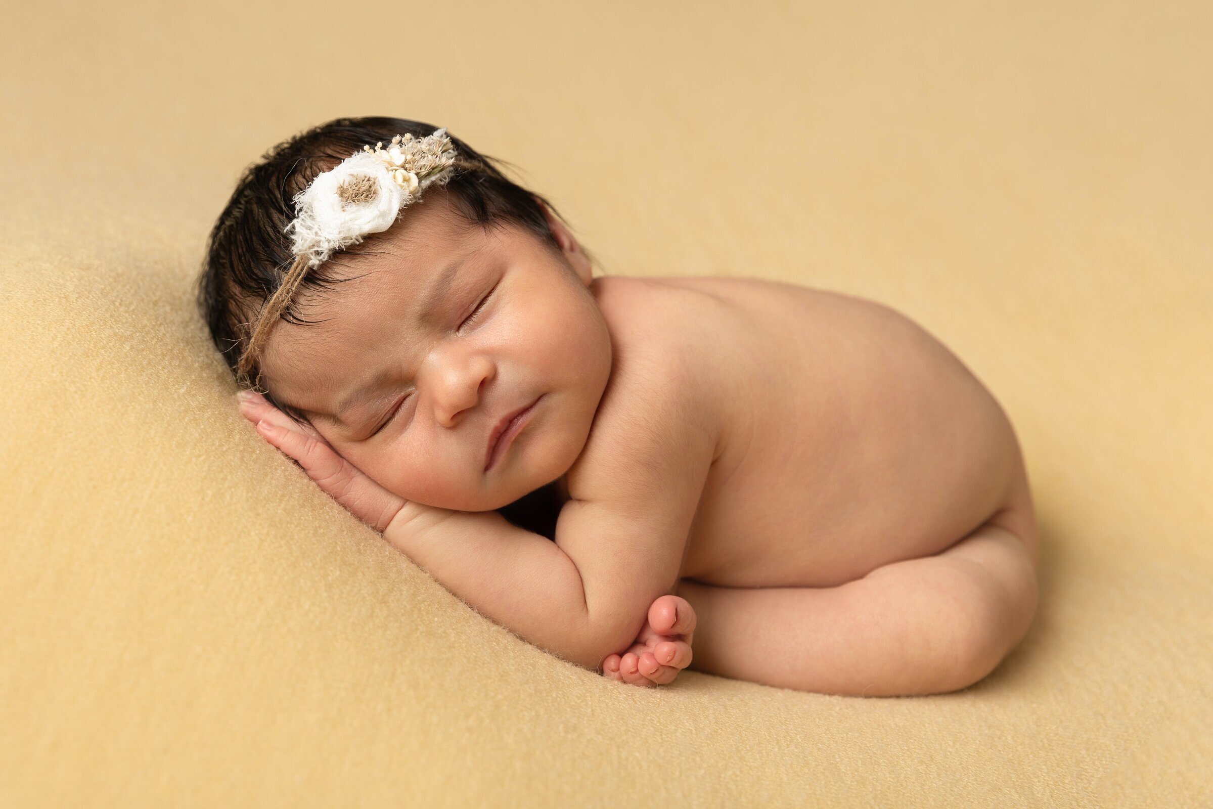 newborn-baby-with-headband-taco-pose-on-yellow-background