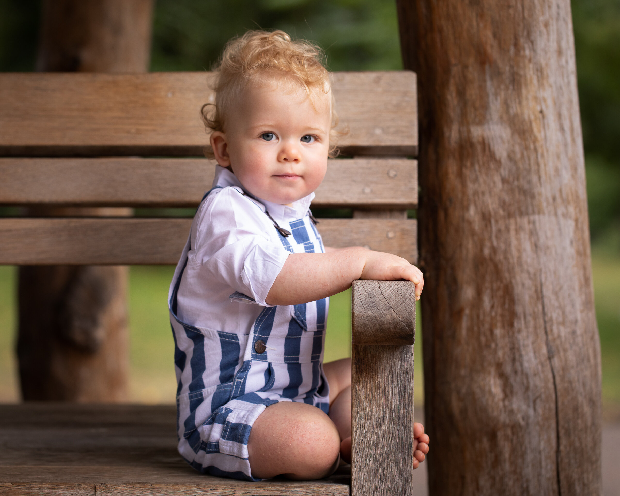 baby boy sitting on bench