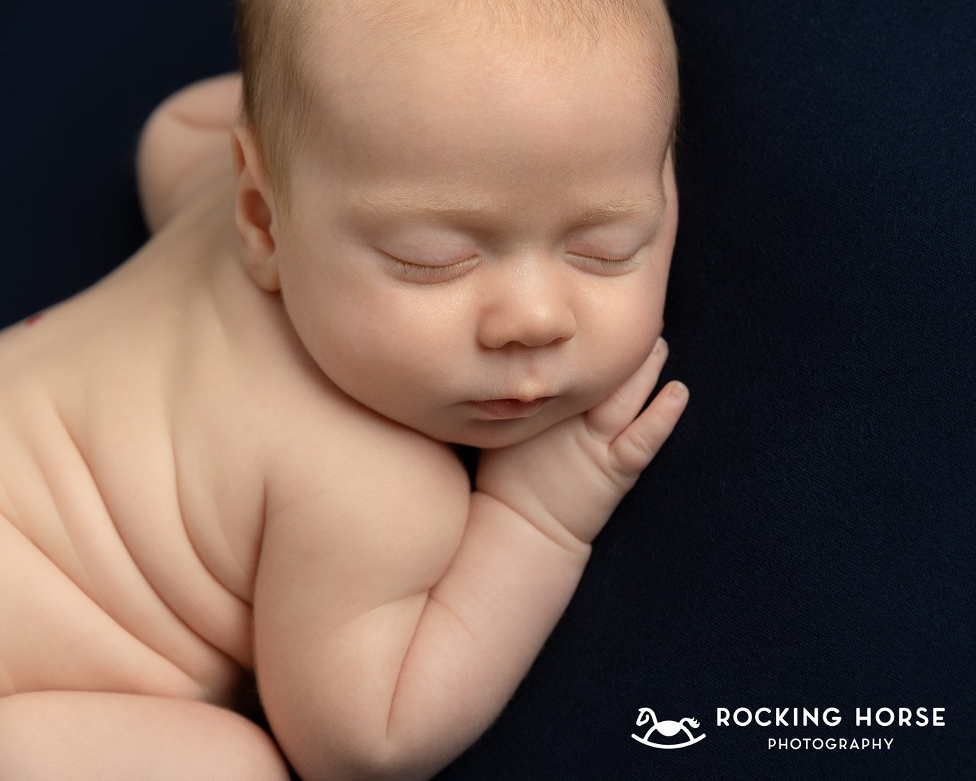 curled-up-newborn-baby-hand-under-cheek 