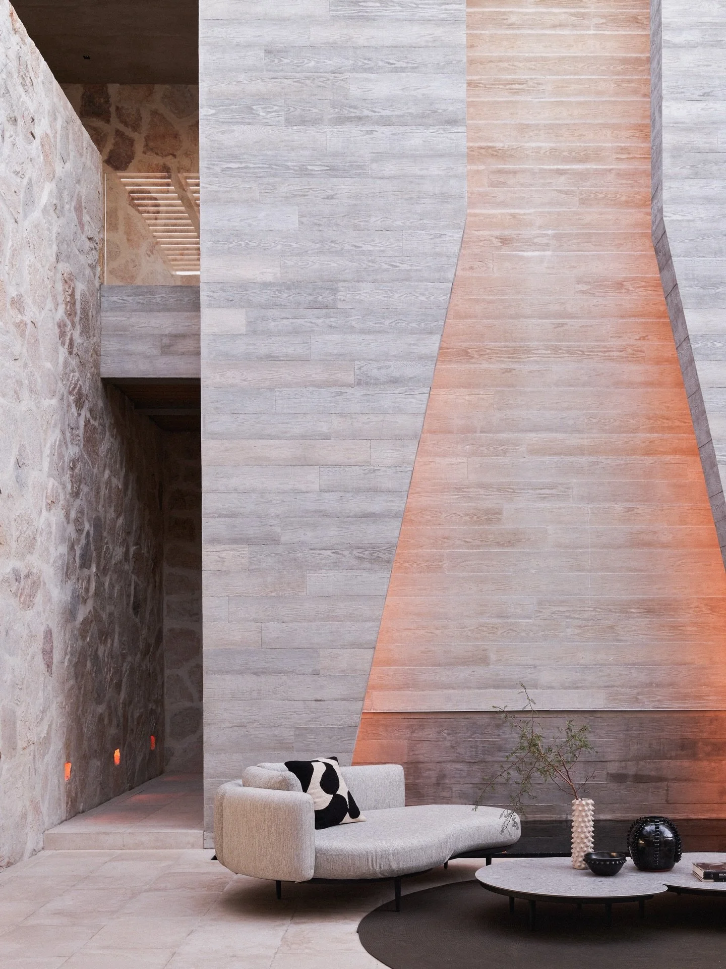 The soft glow from this two-story cascading water feature helps illuminate the interior courtyard at Eldorado as the sun sets over the ocean horizon in Los Cabos. The geometry of the board-formed mass is simple but dramatic as it tapers out toward th