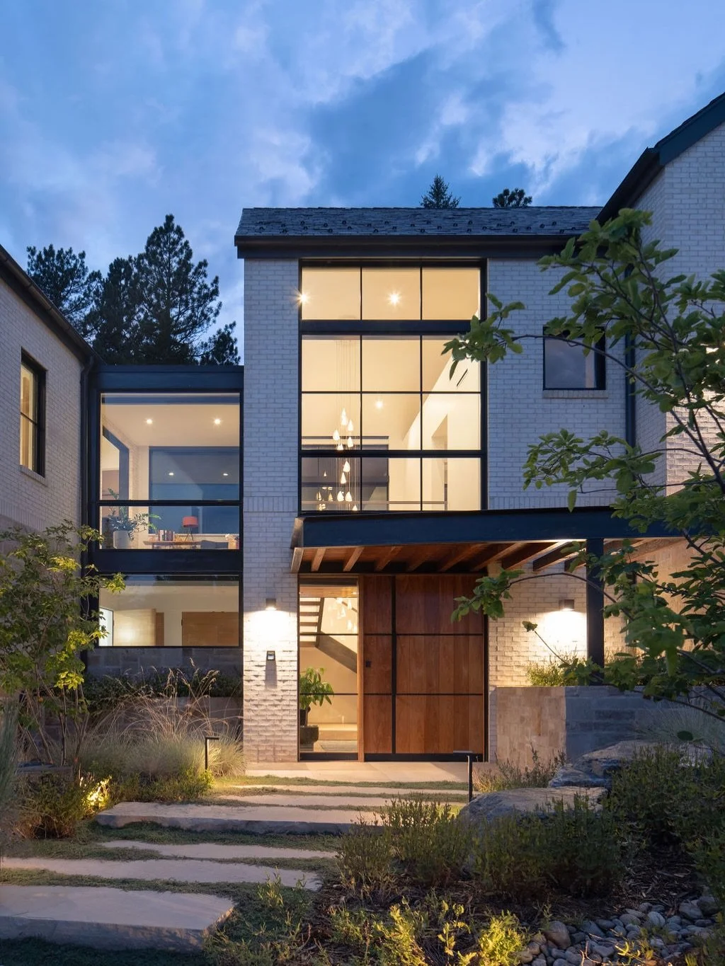 Arriving through the 5-by-8 walnut pivot door, you&rsquo;re greeted by a modern expression of the grand entry stair. White oak open treads wrapped in blued steel ascend the double height foyer, where the ephemeral porcelain @bocci pendant is experien