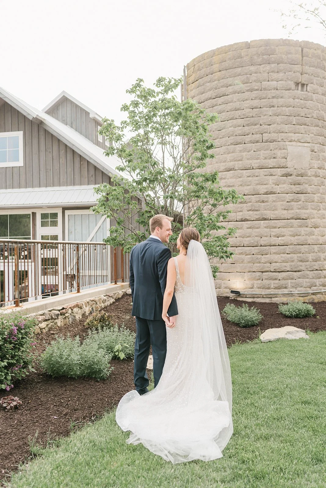 Bride and groom smiling with backs to camera