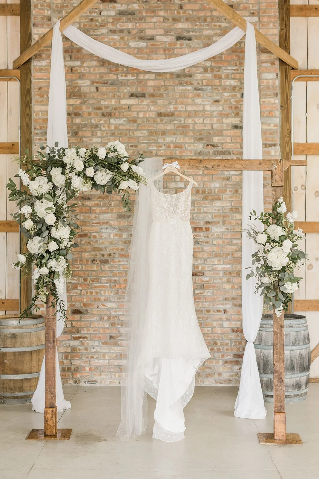 Bride's dress hanging from ceremony arch