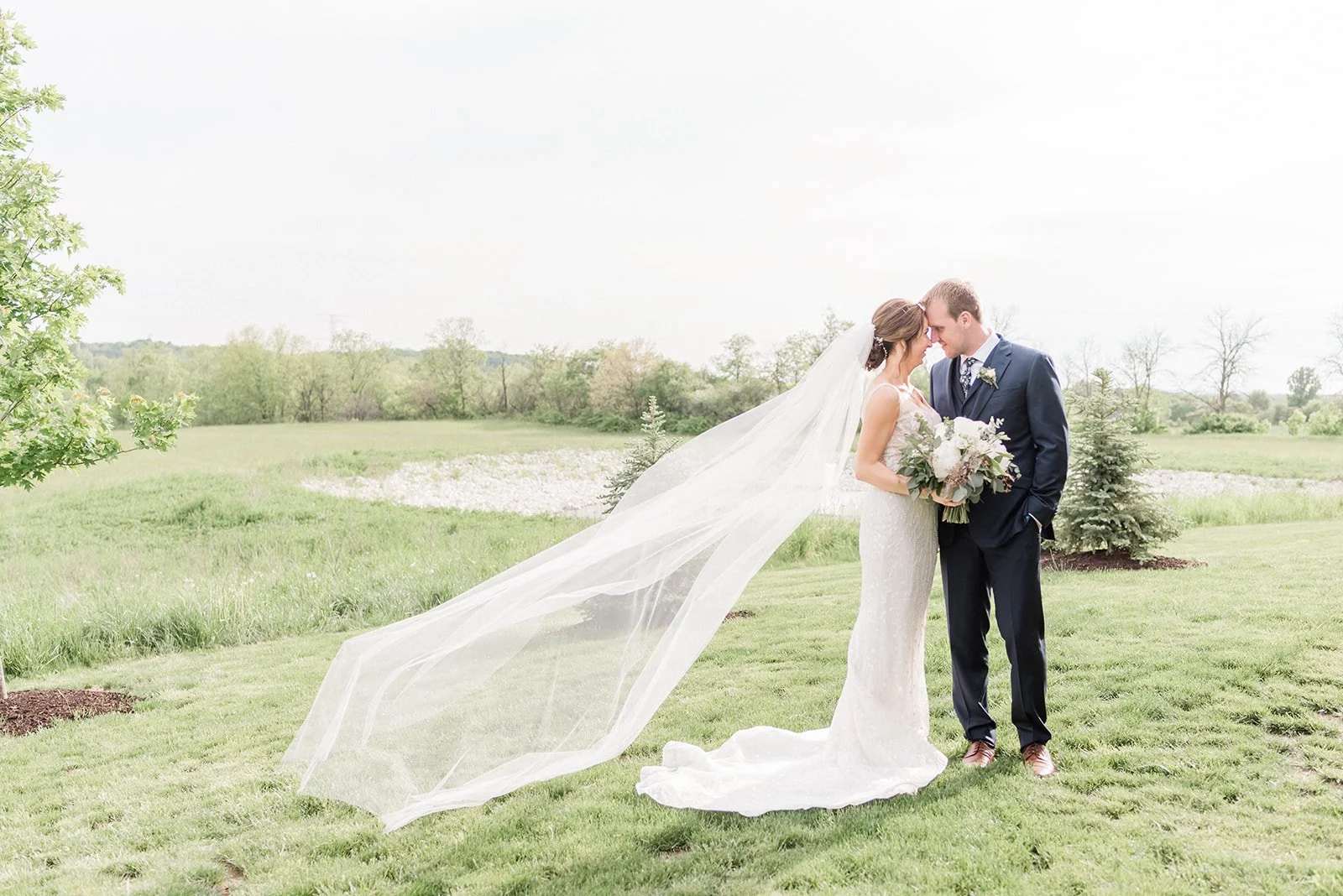 Bride and groom posing in field