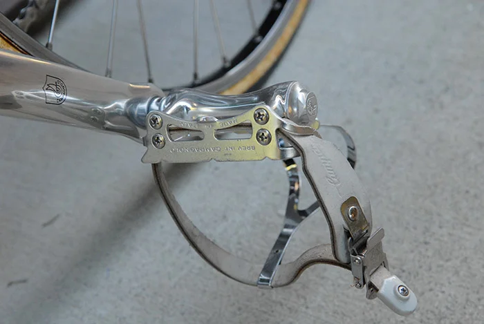 Campagnolo C record road pedals were available in four different version in 1987 and 1988. Thes pedals are the "second" version. Campagnolo described this version as "“The second pedal, ergonomically designed, is ideal for cyclists used to pedalling ‘round’ where the ball of the foot exerts the maximum force of the push. The two plates, equidistant from the central axle, guarantee minimum stress to the foot."