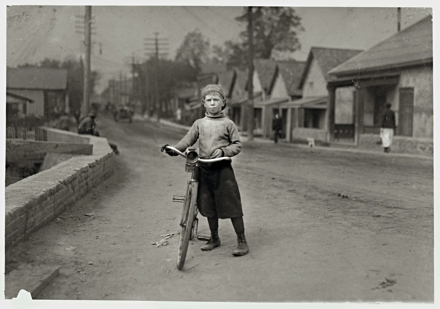 Isaac Boyett, “I’m de whole show.” Waco, Texas “The twelve year old proprietor, manager and messenger of the Club Messenger Service, 402 Austin Street, Waco. The photo shows him in the heart of the Red Light district where he was delivering messages as he does several times a day. Said he knows the houses and some of the inmates. Has been doing this for one year, working until 9:30 P.M. Saturdays. Not so late on other nights. Makes from six to ten dollars a week.” November 1913