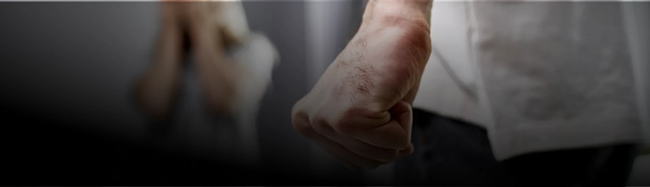 Close-up of an elderly person's hand holding a glass of water.