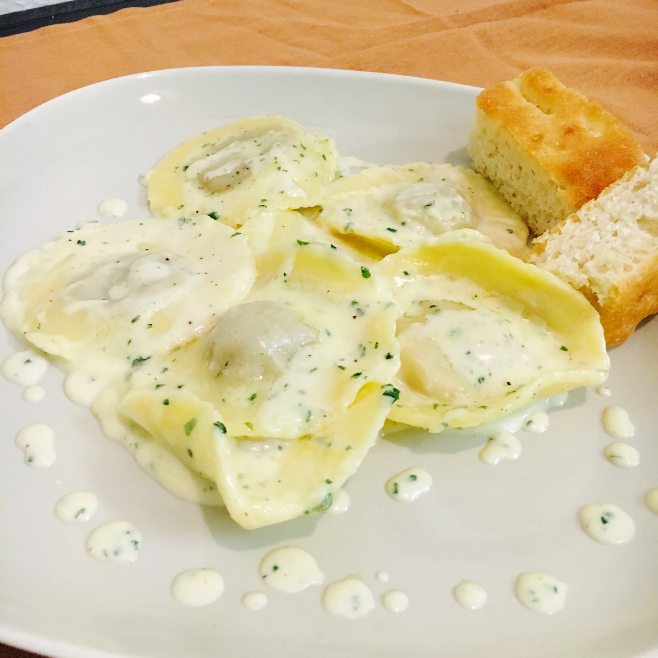 Fresh hand-crafted Porcini Ravioli with a heavy cream sauce and focaccia 