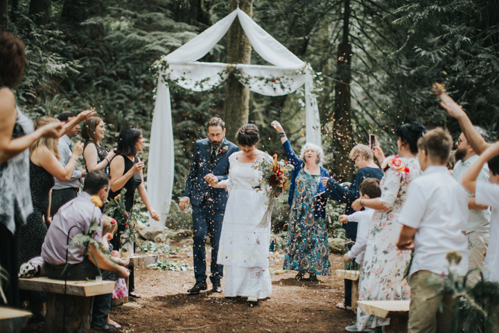 Walking away as man and wife getting covered in dried flowers.