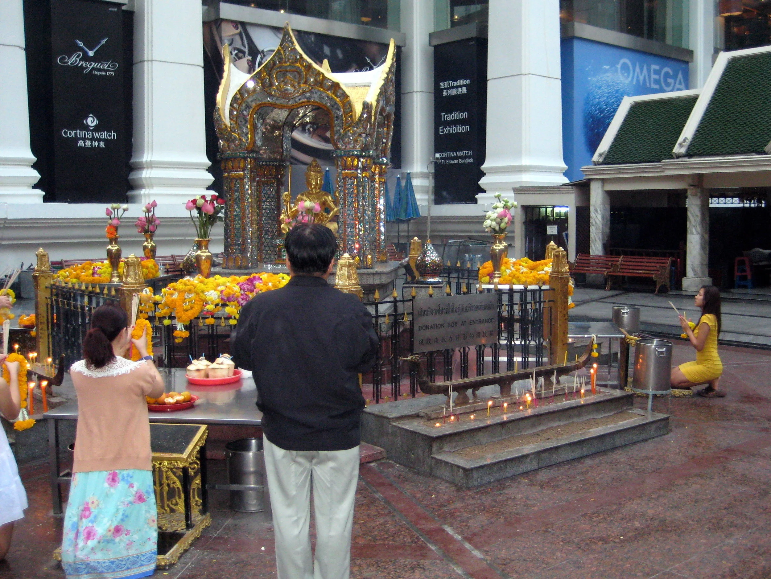 This is a rather famous Buddhist shrine at the corner of the opulent Erawan shopping mall