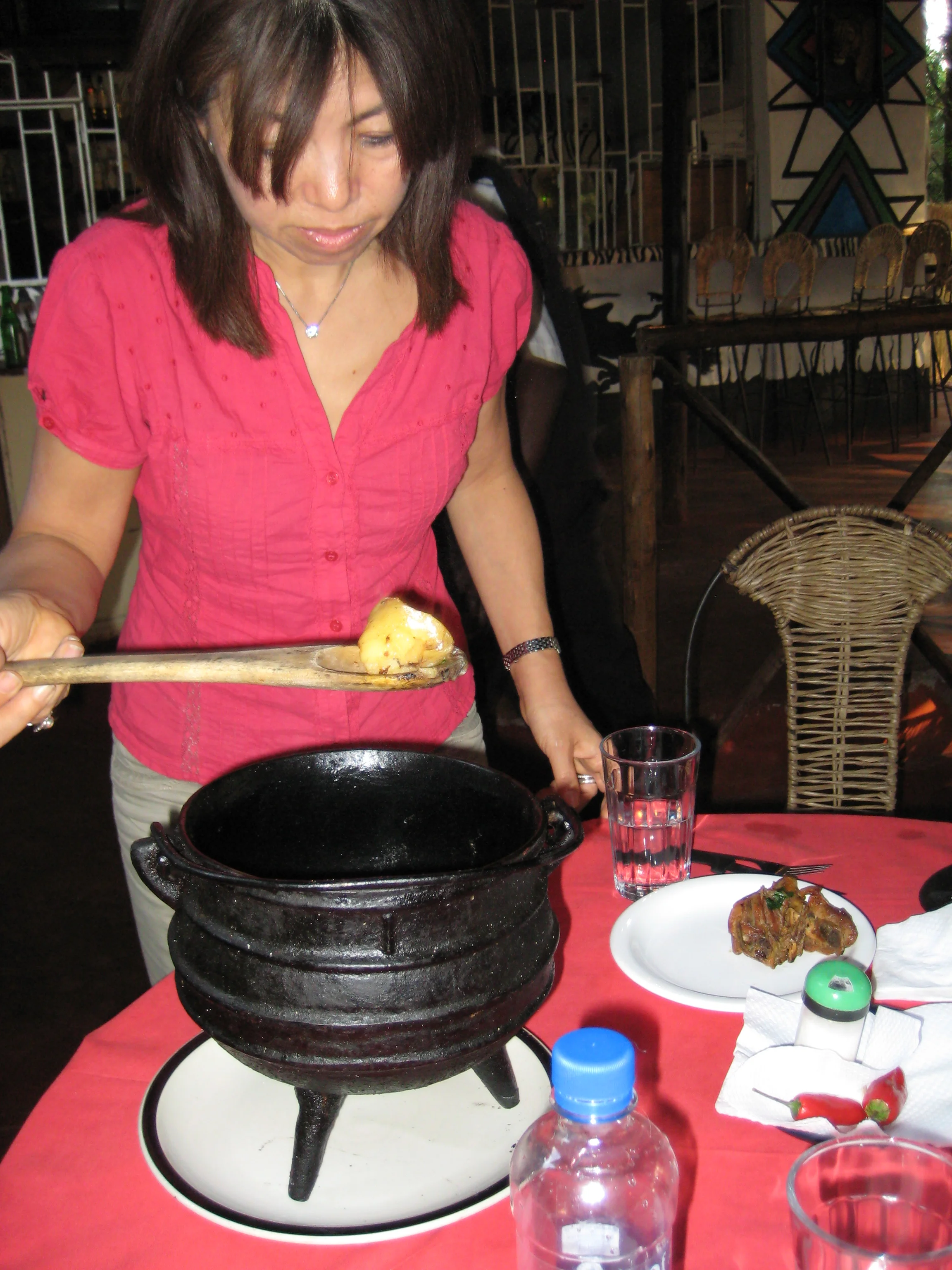  Yumiko dishes up from the cast iron pot at Nyama Choma, The Kraal, an ethnic Gocha restaurant. 