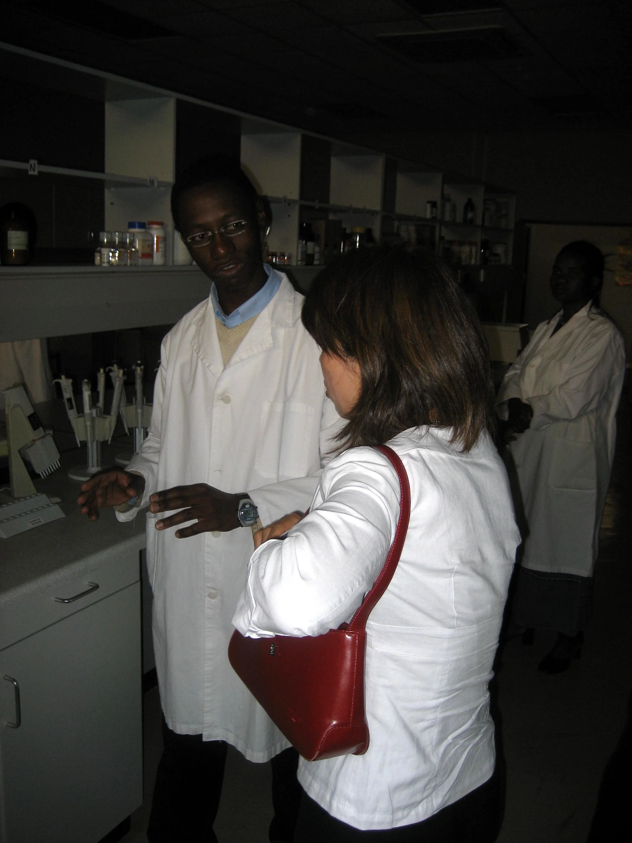  An SIRDC researcher explains his work in developing new strains of drought-resistant maize. The lab equipment was very sophisticated. &nbsp;But why so dark? While we were visiting, the lab suffered from one of the frequent power outages in Harare. A
