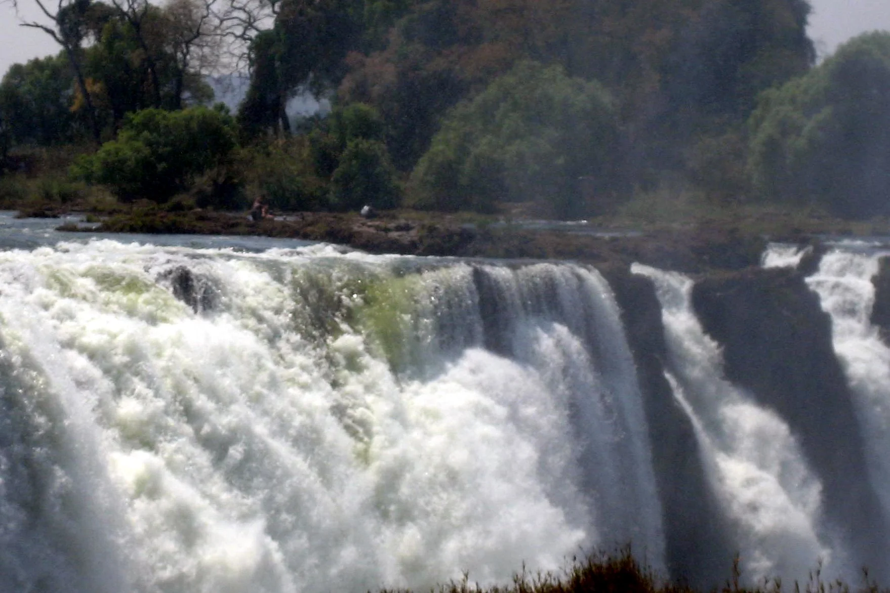  Along the edge of the Falls (just left of center here), you can see quite a few people fishing, bathing and swimming--it appers dangerous as they are so close to the edge. 