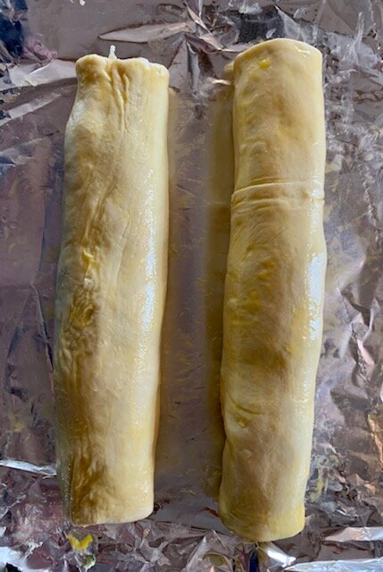 Rolling up puff pastry filled with mixture.