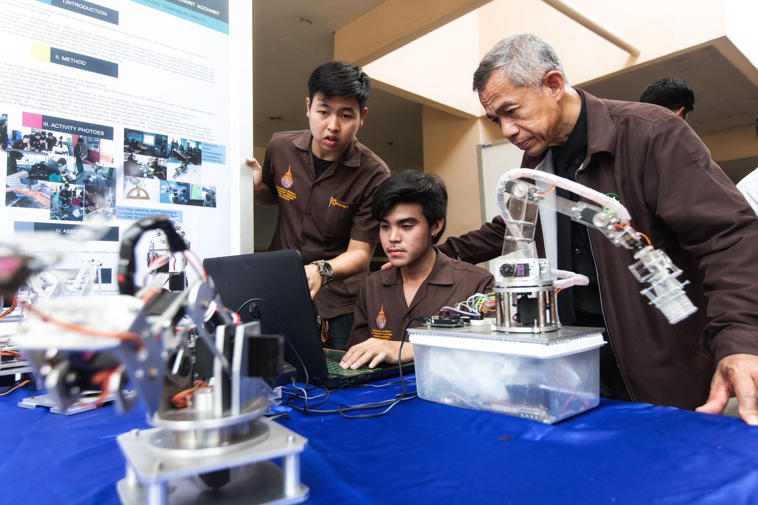  As part of CDIO’s active learning, students design and build real-world solutions. Industrial Engineering students Takonkiat Arirob (centre), 23, and Udomsak Wattanagool, 22, carry out a demonstration of the robotic arm they created with supervision
