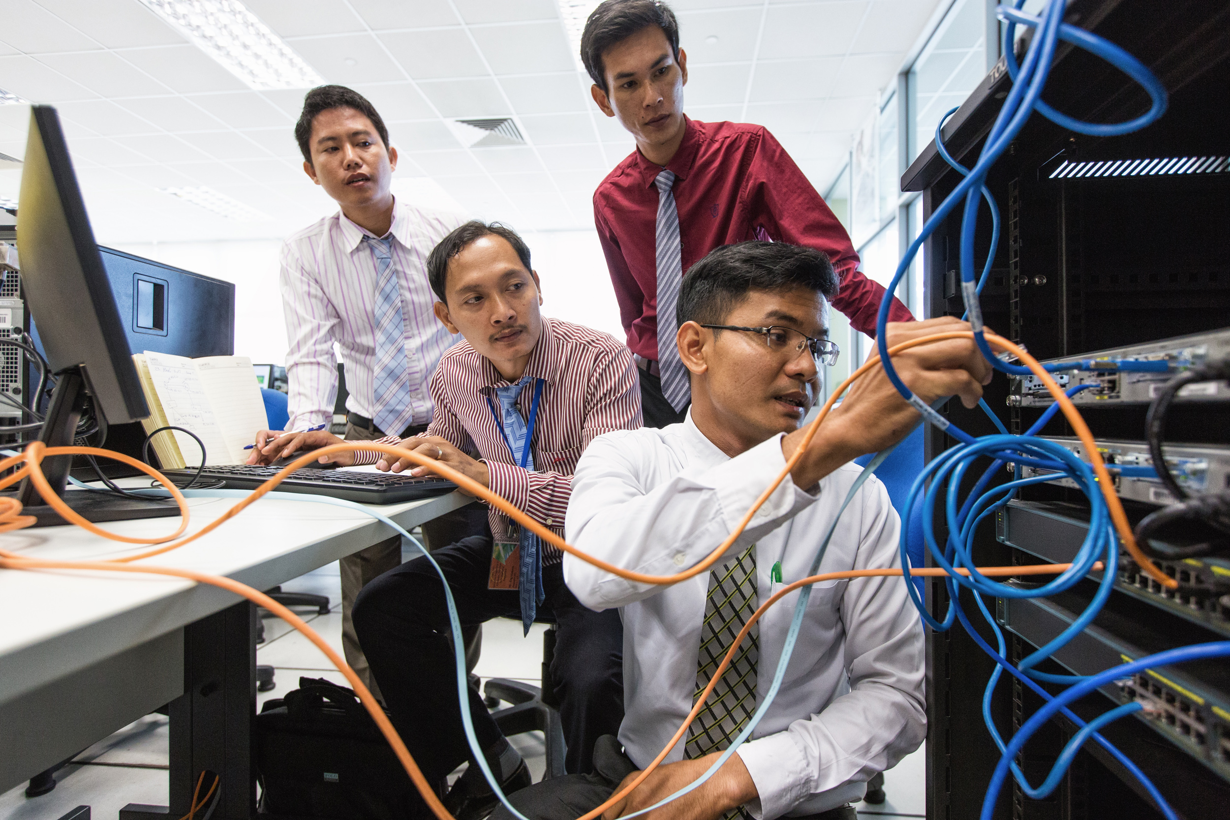  Piseth Keo (right), 27, an information communications teacher from the Koh Kong Provincial Training Centre, Cambodia, setting up a computer network with three TVET participants. They are in the Computer Technology Lab of Singapore’s ITE College East