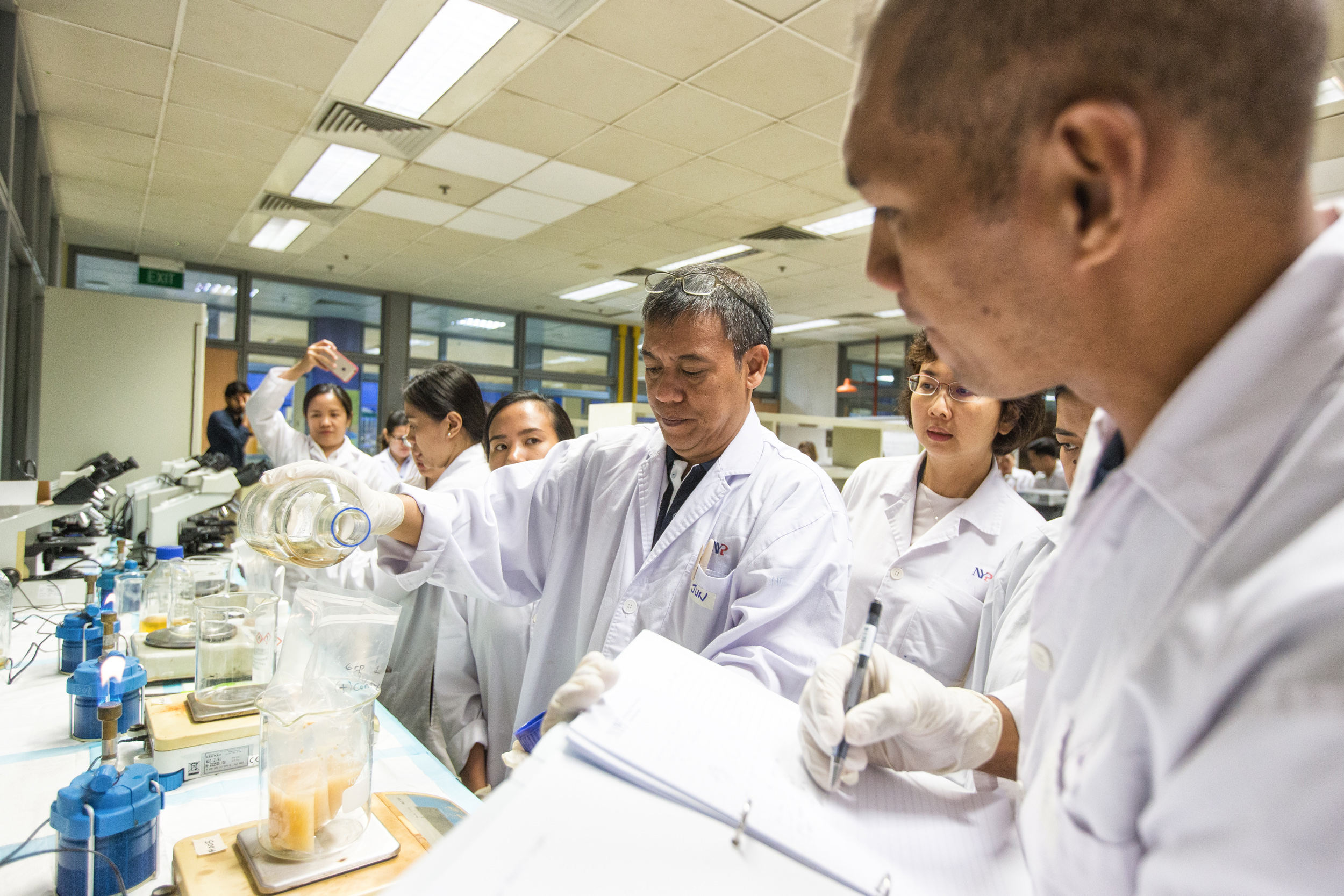  Jun Leo (centre) pours in the milk samples to its specific amount for microbiology testing. Other samples that are used for testing include salads and raw seafood-based foods. 