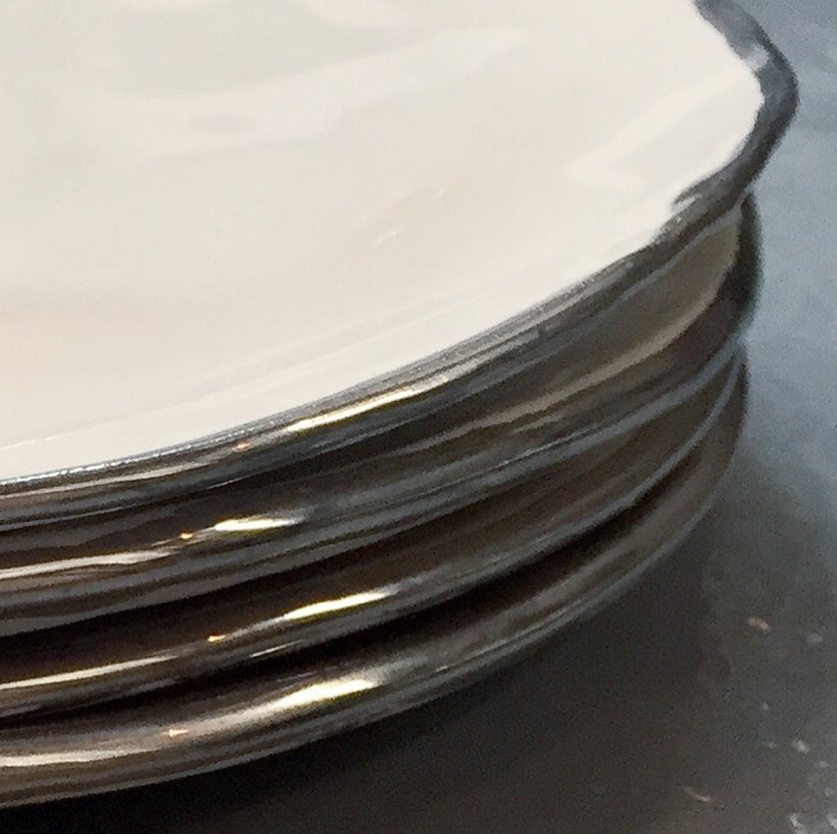 Stack of white gold lustered dessert plates for The Pool restaurant