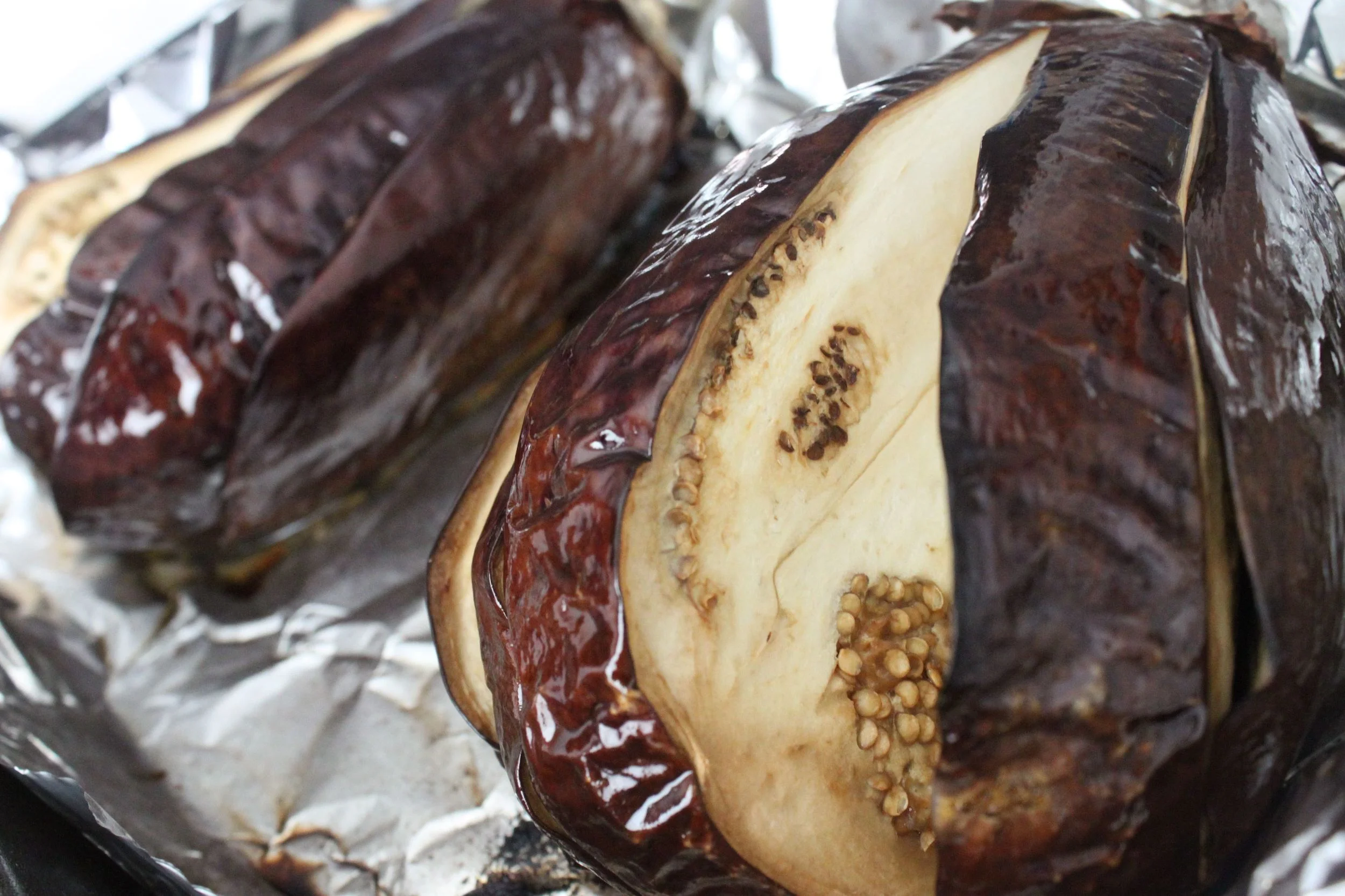 how the eggplants should look when you remove them from the oven. also note the lengthwise cuts!