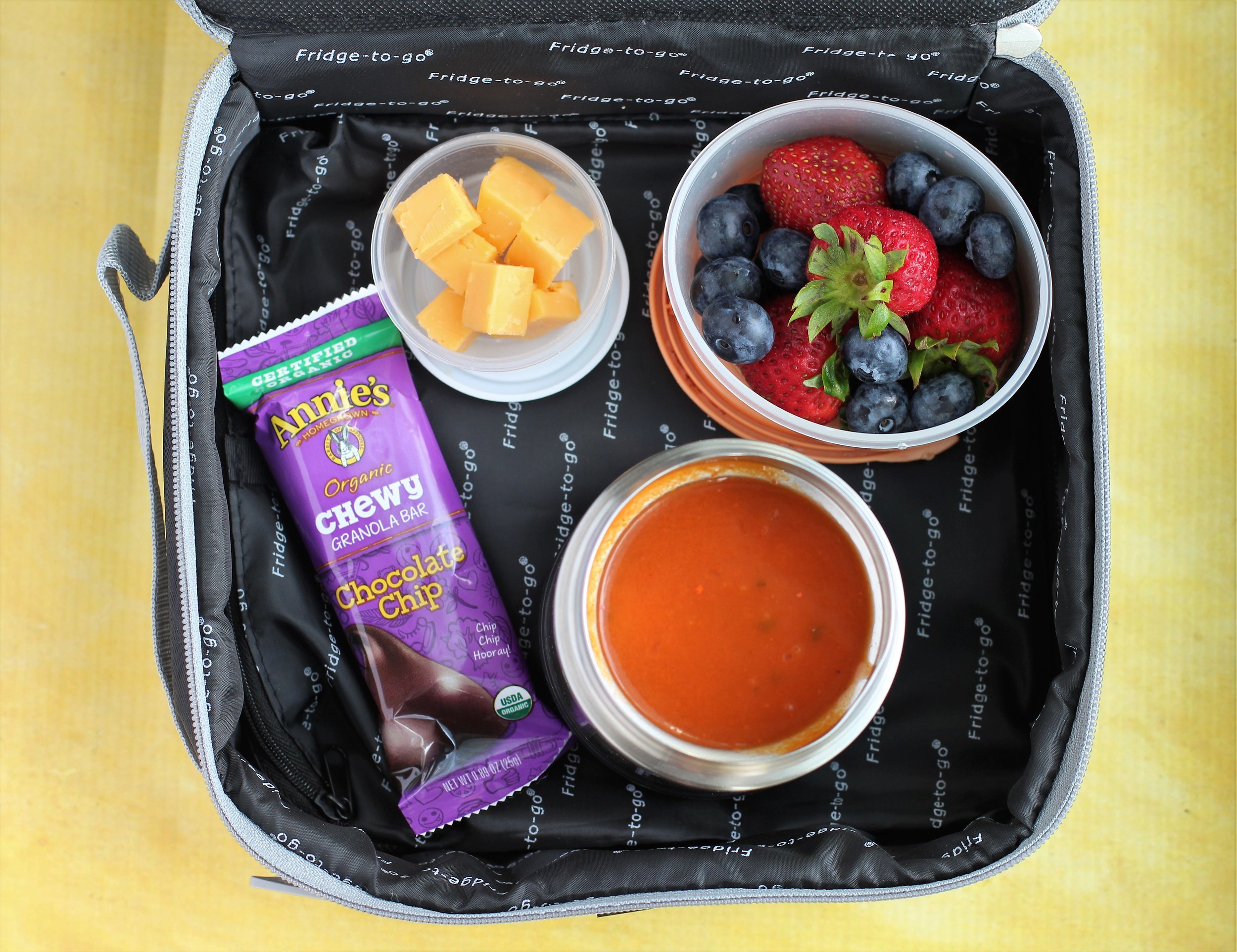 Leftover tomato soup, granola bar, cheese cubes, and berries