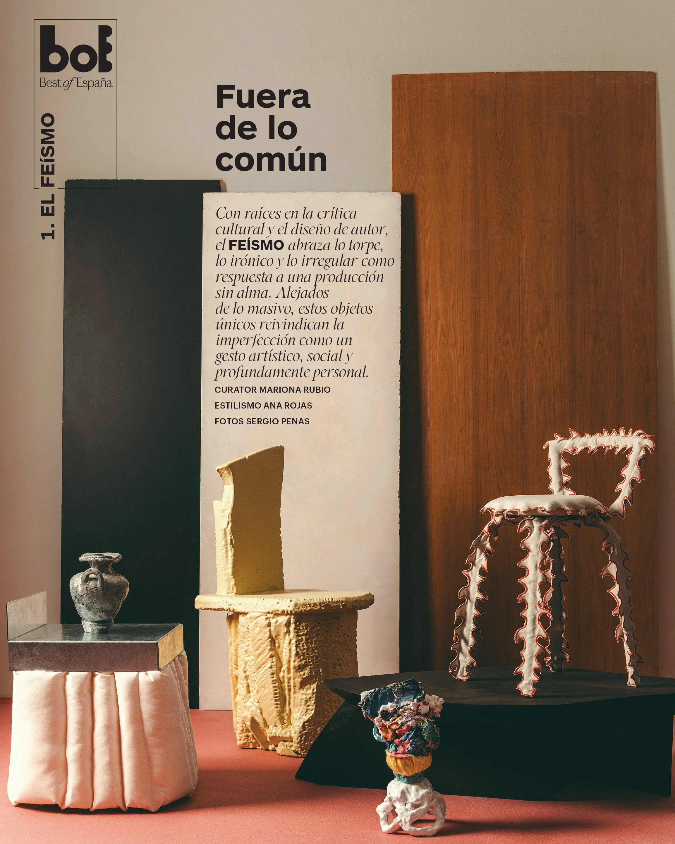 Display of various art objects including a small sculpture on a pink fabric-covered stand, a tall yellowish sculpture, and a large chair with wavy edges on a black platform, with informational text and a wood panel in the background.