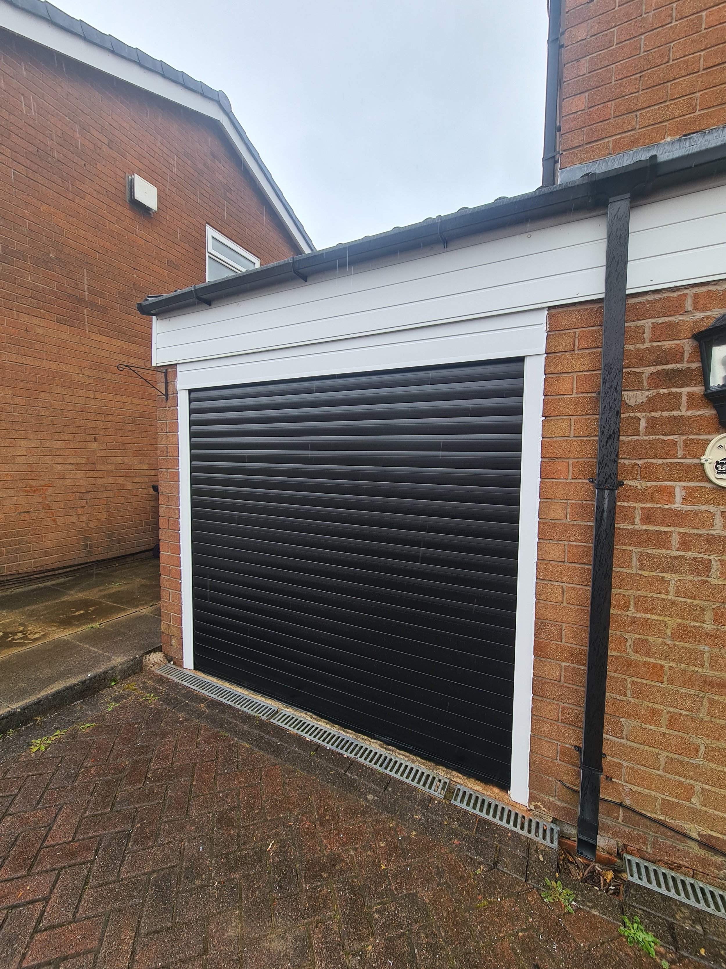 Uk Doors Midlands Classic 77m fully insulated roller garage door in smooth Black W/ White frame