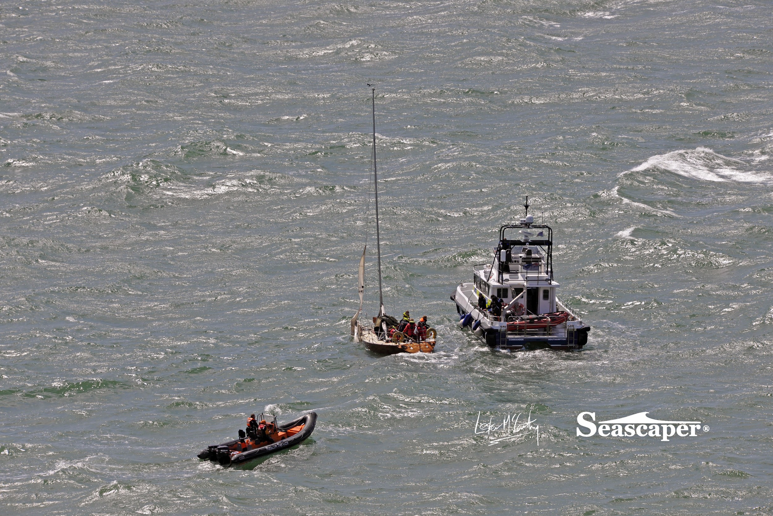 The crew prepare to abandon Alchemist and transfer to the Police high speed catamaran, a coastguard rib is seen standing by.