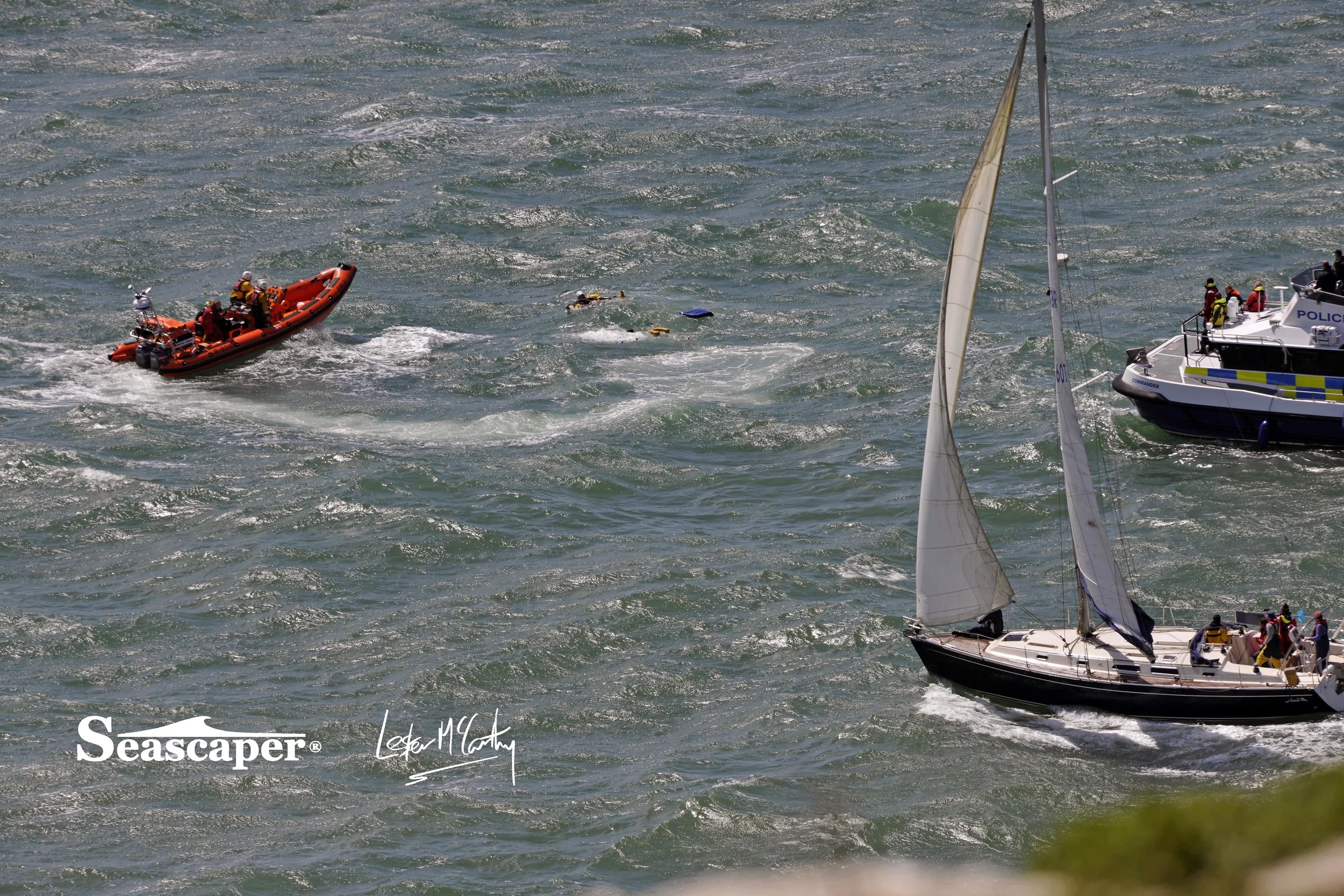 A RNLI lifeboatman appears amongst the flotsam.
