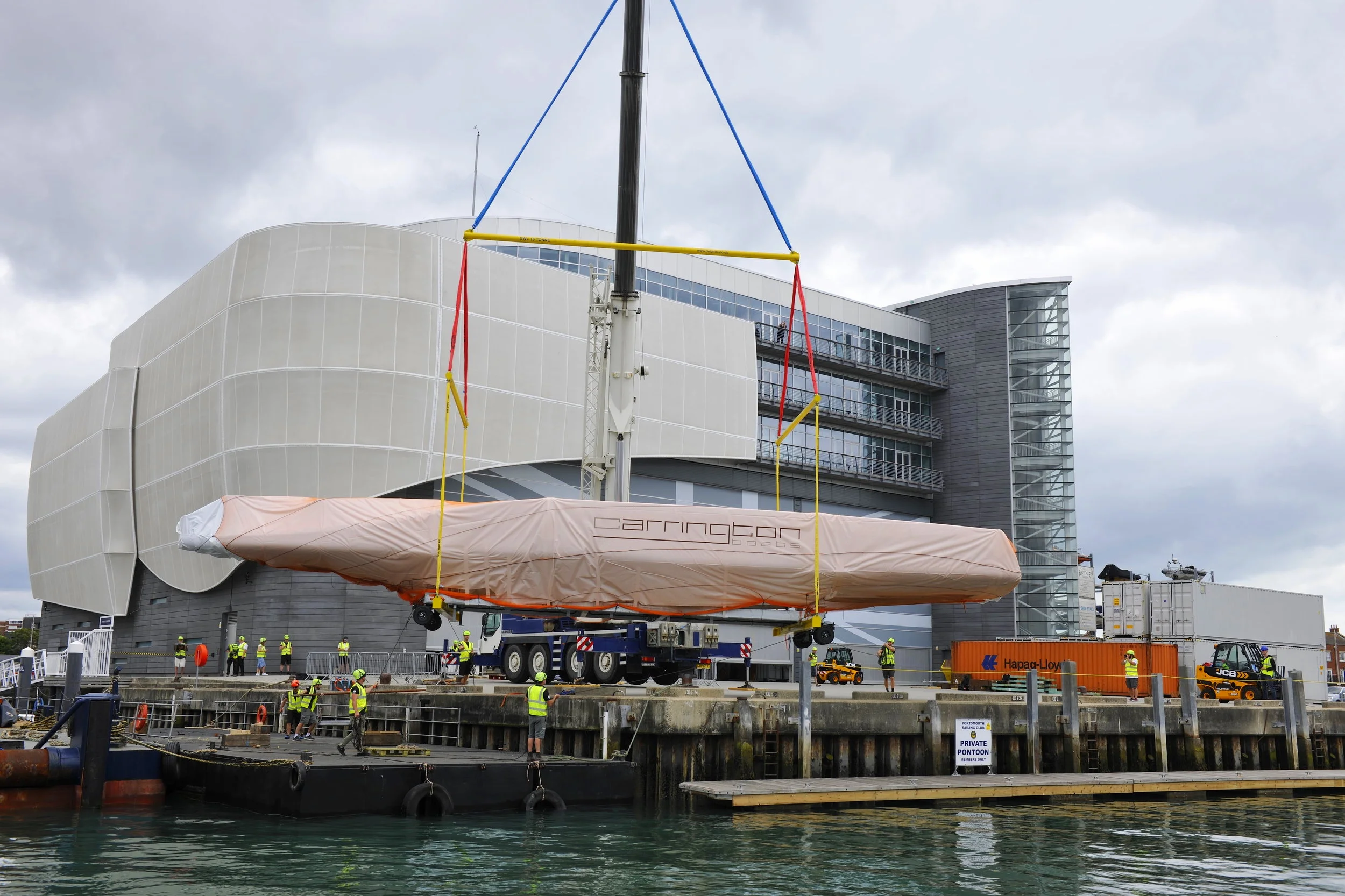 Sir Ben Ainslie’s new 75ft foiling mono-hull arrives today and is craned from the barge to its dockside home at Ineos UK, Camber Dock, Portsmouth.